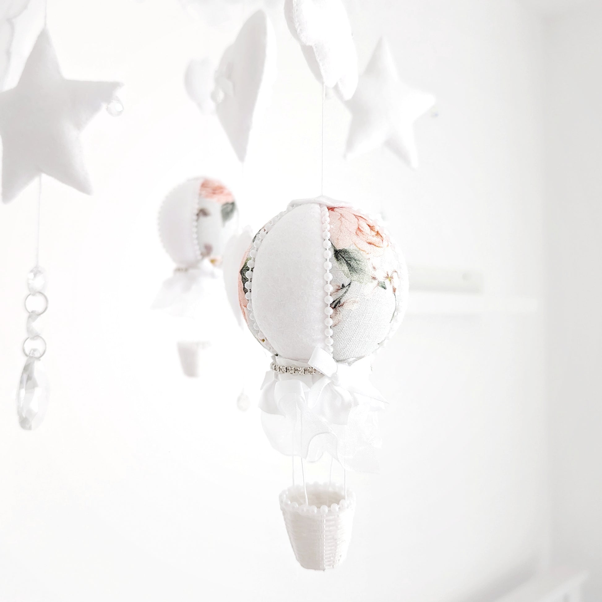 Handcrafted luxury baby mobile featuring floral balloons, clouds, and sparkling details on a round canopy-style frame.