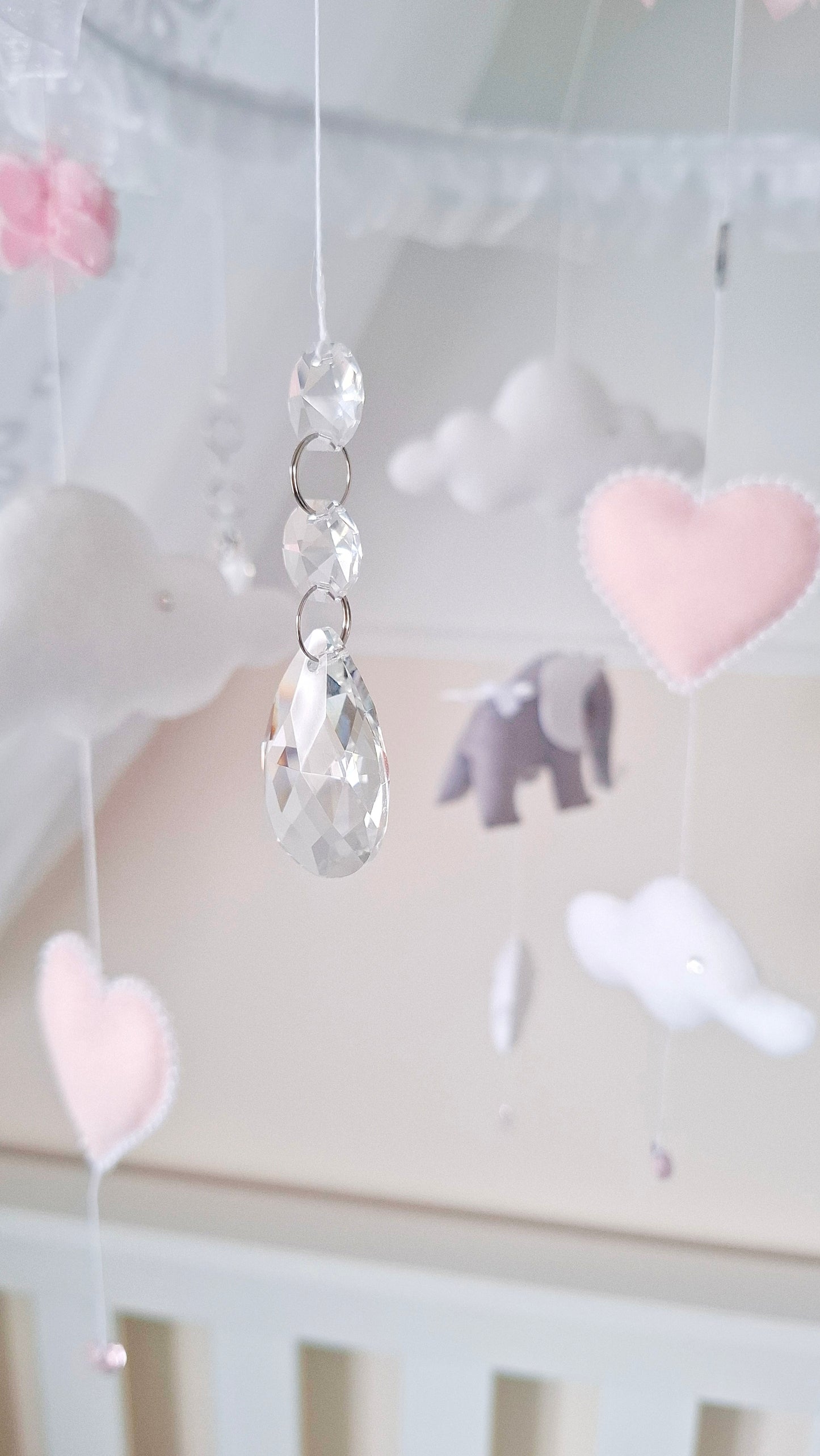 High-end baby mobile with dreamy clouds, tiara-topped elephants, and romantic pink heart details for elegant nurseries.