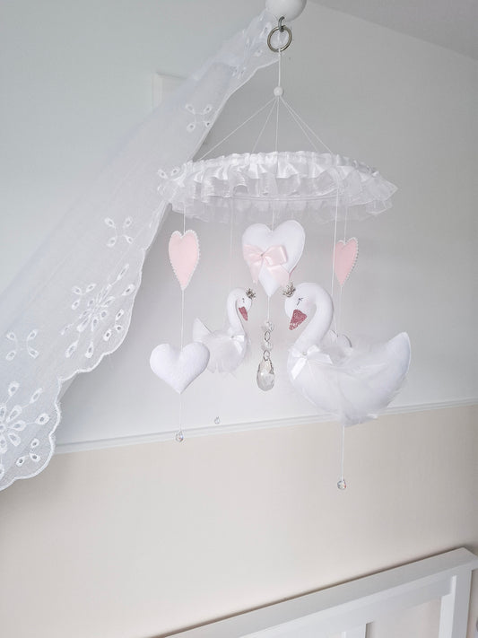Luxury swan baby mobile in soft pink and white tones, handmade with felt swans, hearts, and crystal touches for a dreamy nursery centrepiece.
