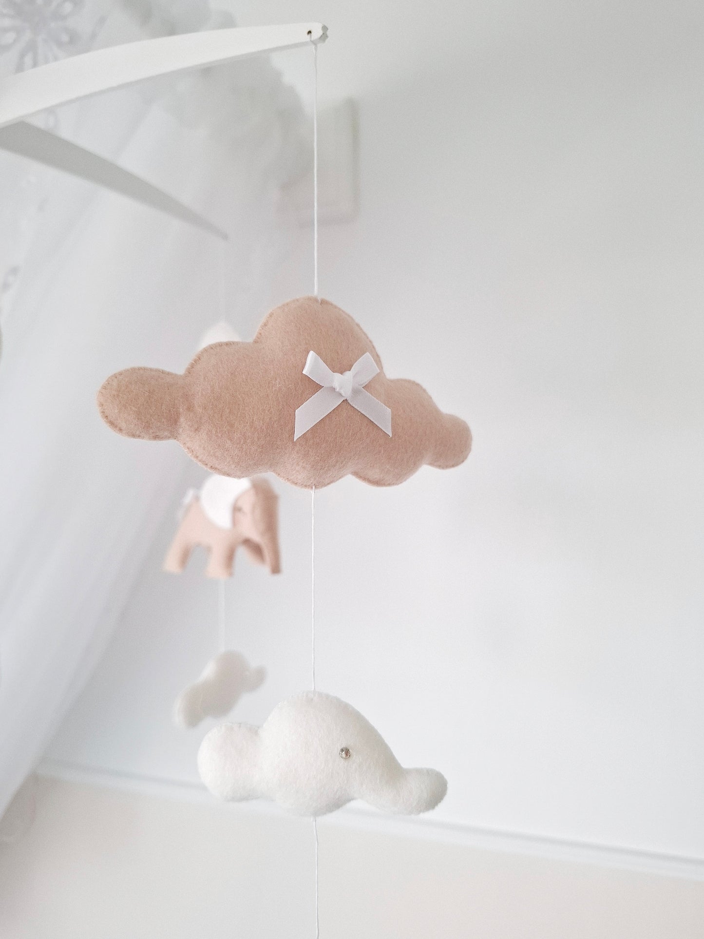 Side view of neutral elephant mobile featuring floating white clouds and soft detailing for a calm and dreamy nursery space.