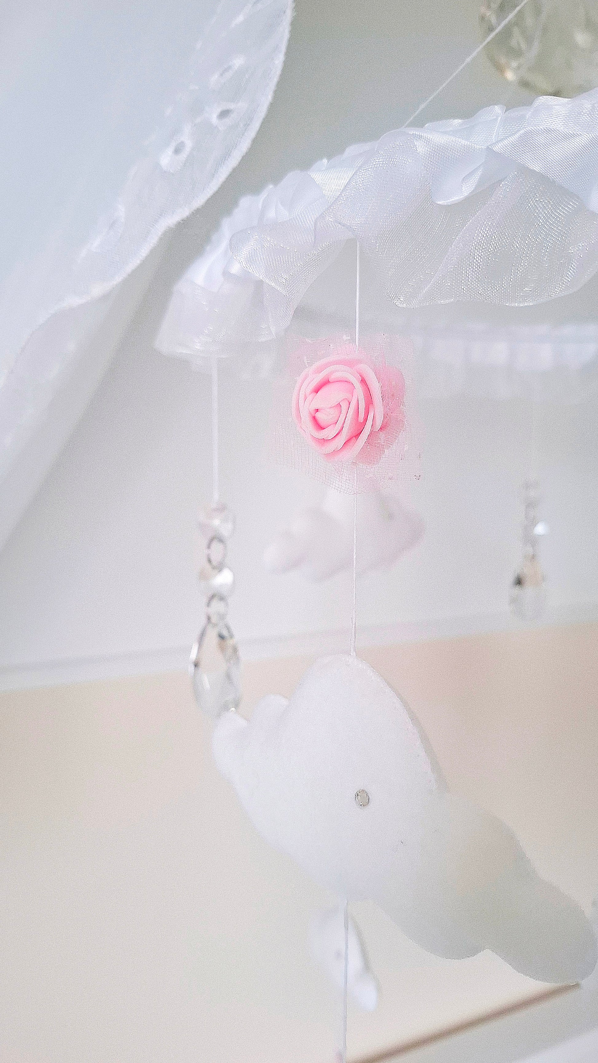 Princess-inspired nursery mobile with a silver tiara crown, delicate clouds, and pink heart charms for a whimsical touch.