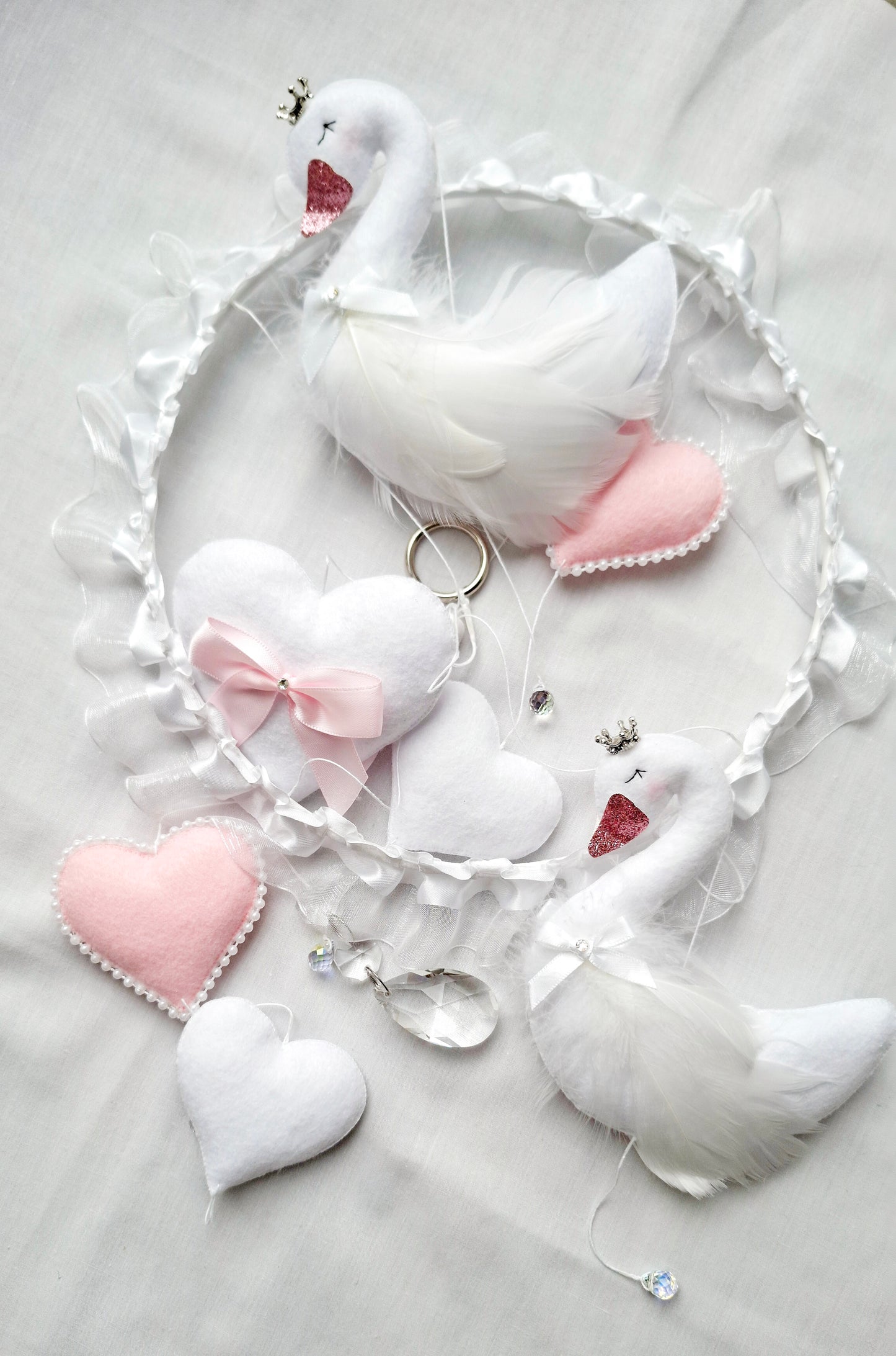 Close-up of soft swan feathers and delicate stitching luxury craftsmanship made to enchant a baby's space.