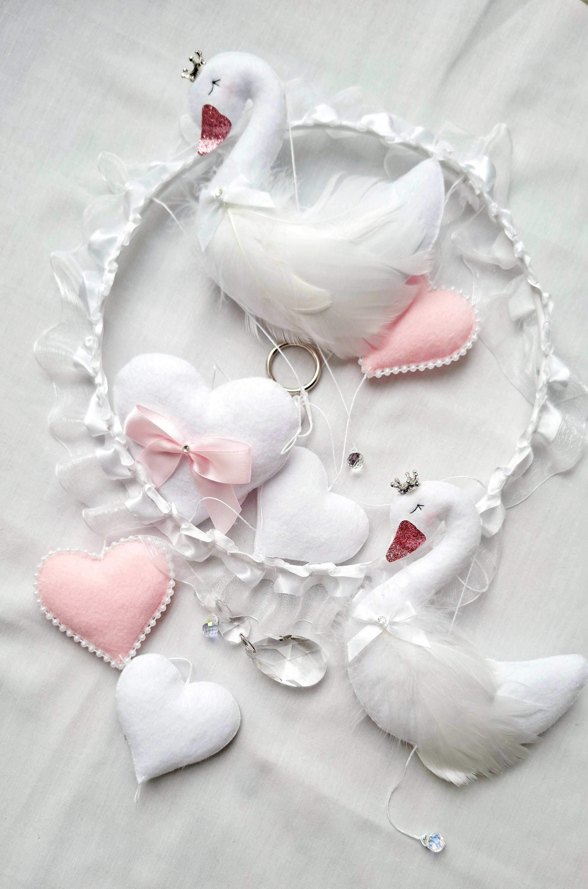 Close-up of soft swan feathers and delicate stitching luxury craftsmanship made to enchant a baby's space.