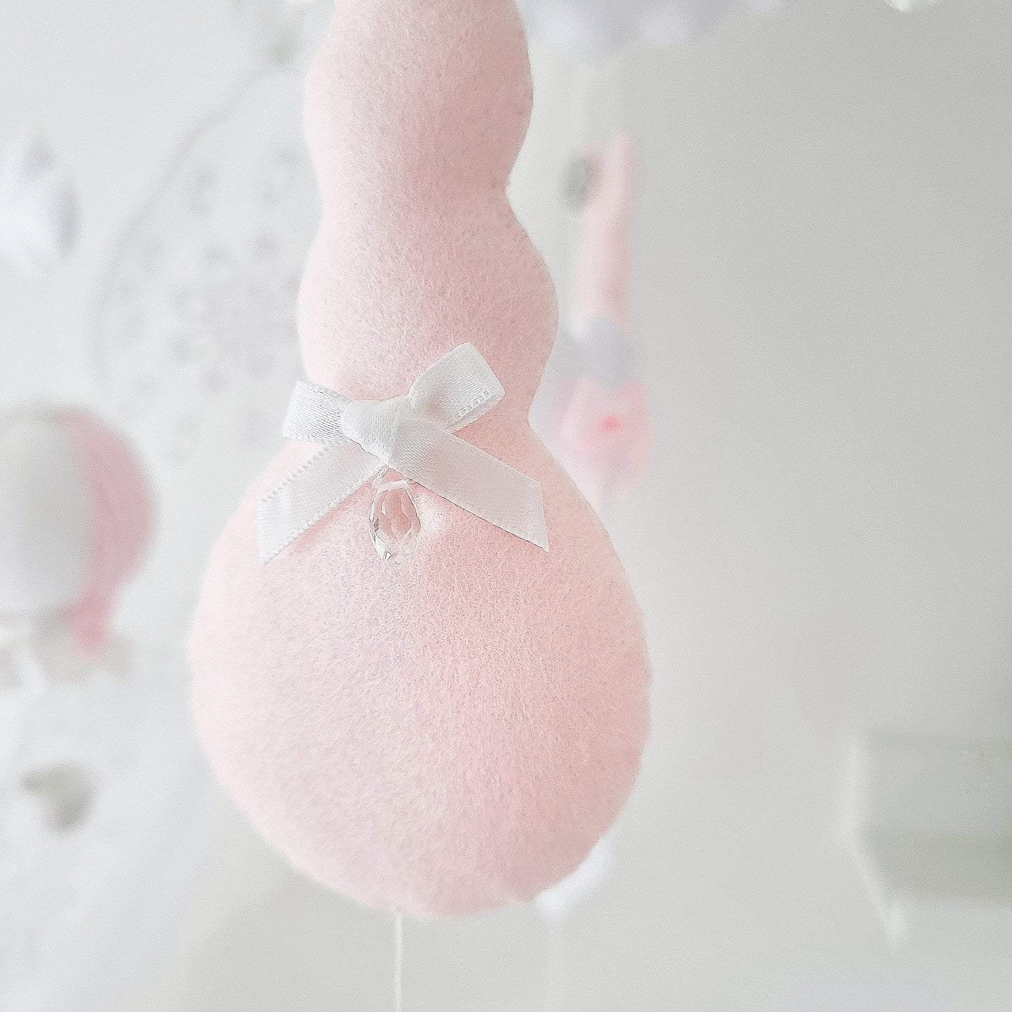 Elegant handmade nursery mobile for a baby girl with soft pastel elements and whimsical hot air balloons