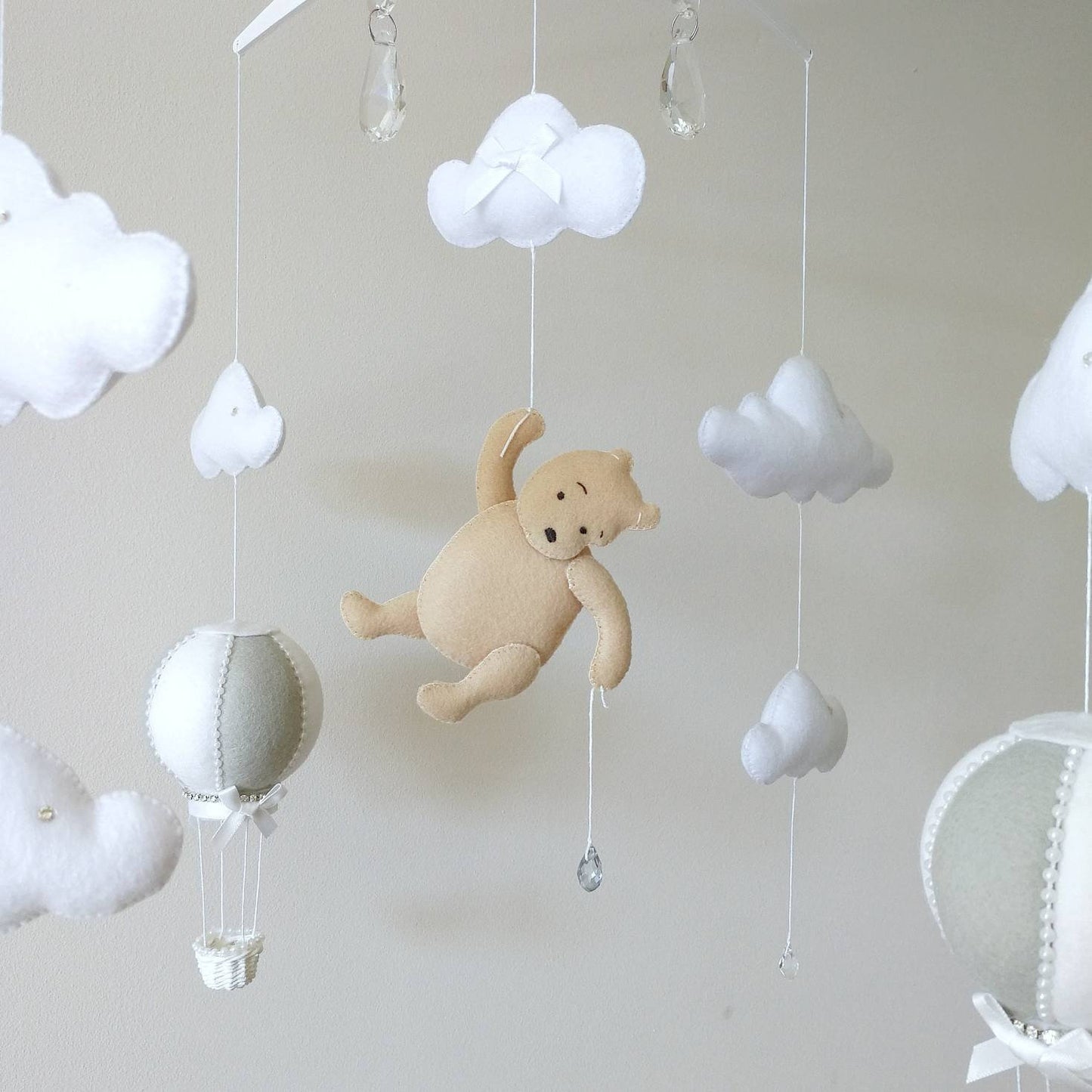 Close-up of a cuddly felt bear resting on a fluffy cloud a gentle centrepiece for a dreamy nursery mobile