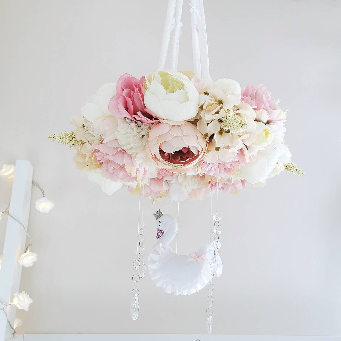 Handmade baby mobile with soft silk flowers and a graceful felt swan nestled among the petals bringing calm and beauty to a nursery