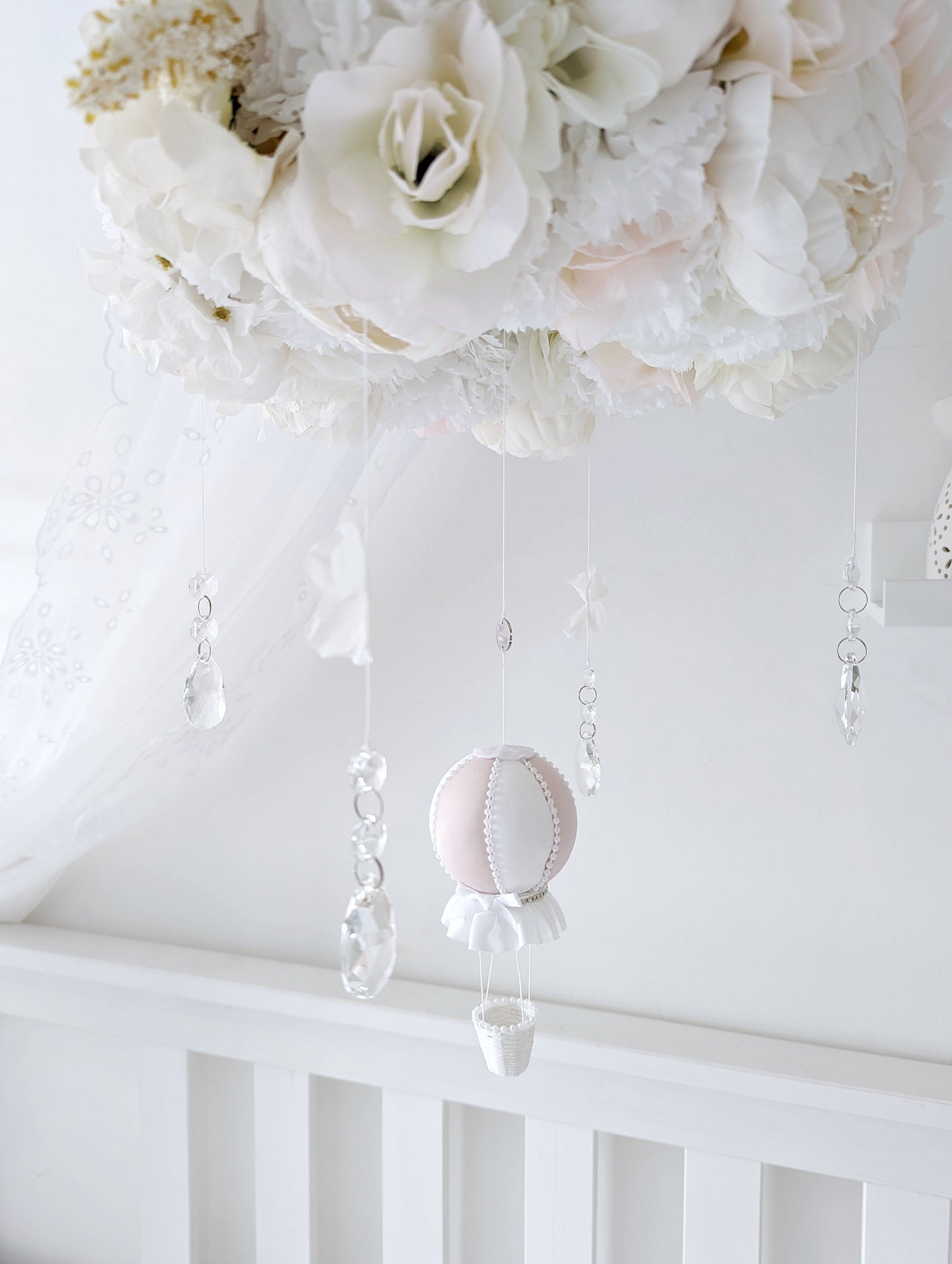 Handcrafted baby mobile with lifelike roses, hydrangeas, and a single hot air balloon, creating a dreamy floral crown look.