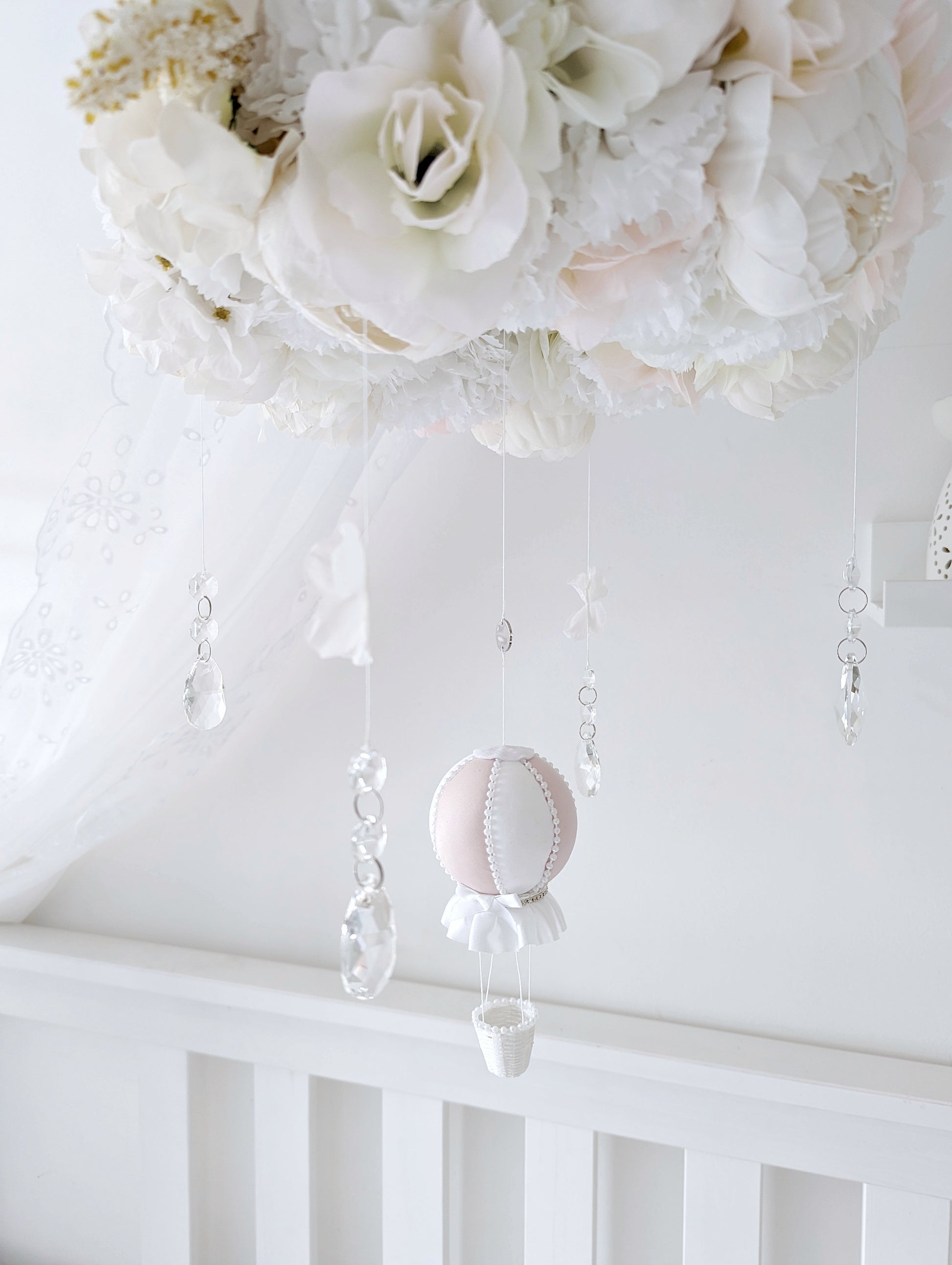 Handcrafted baby mobile with lifelike roses, hydrangeas, and a single hot air balloon, creating a dreamy floral crown look.