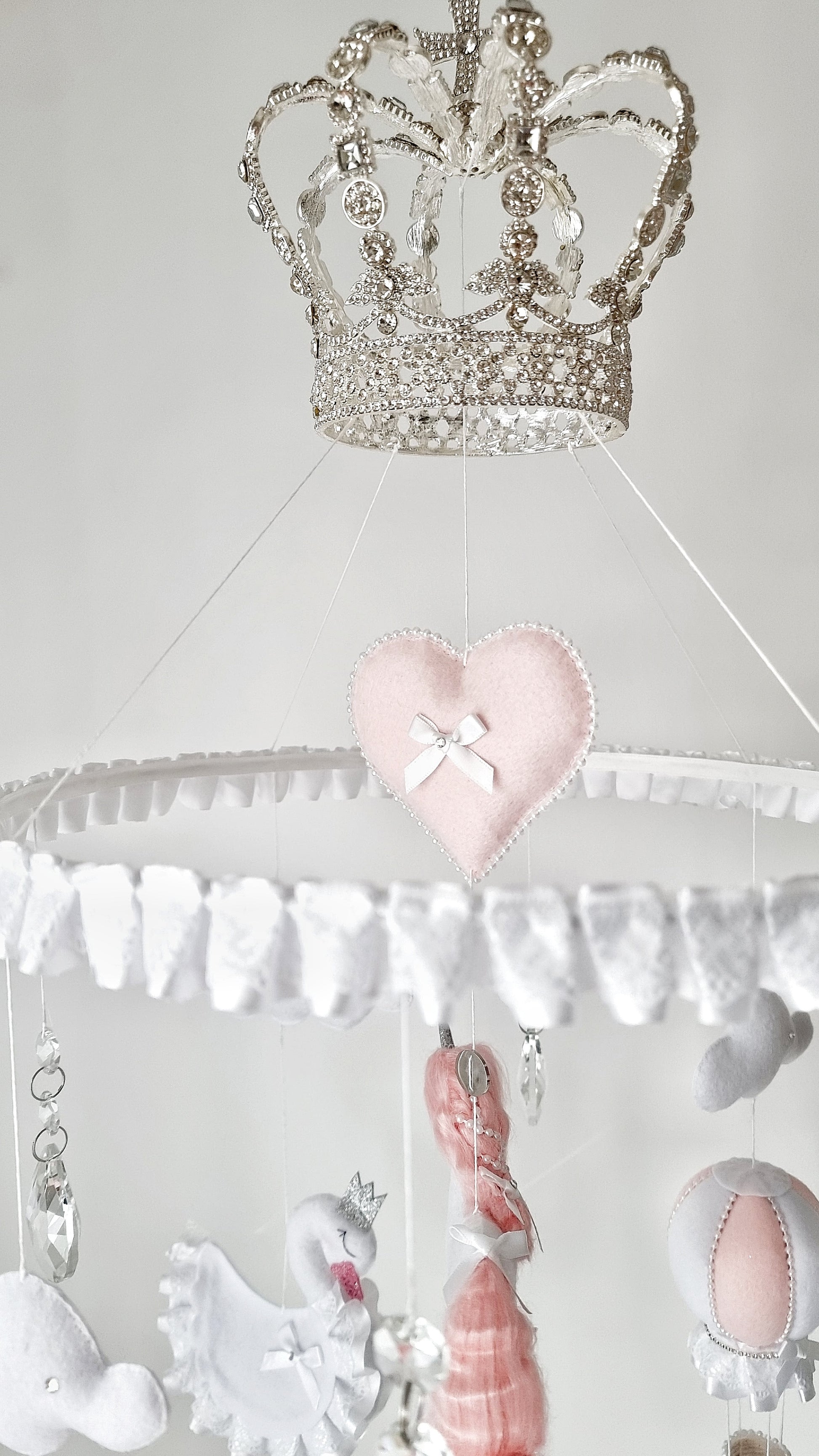 Handcrafted nursery mobile with unicorns, hot air balloons, and soft clouds, finished with shimmering details and gentle pastel tones.