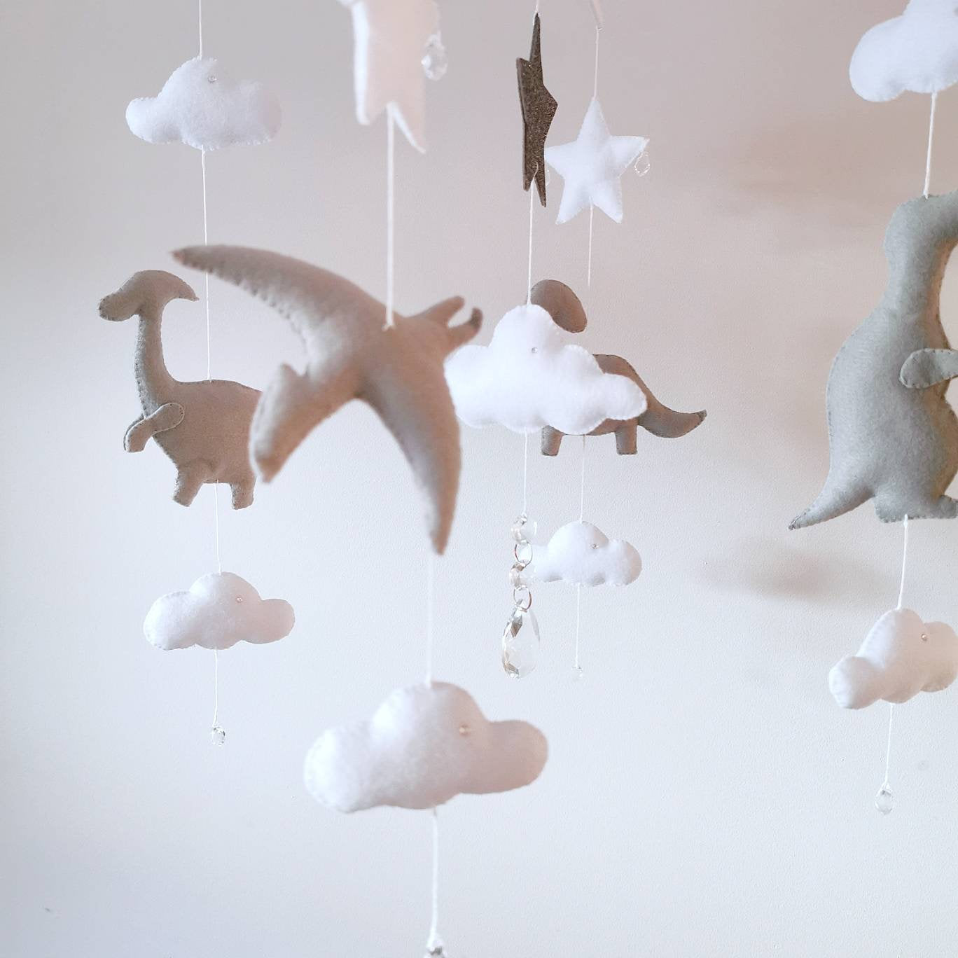 Handmade baby mobile featuring soft grey dinosaurs, clouds, and stars—perfect for a gender-neutral nursery.