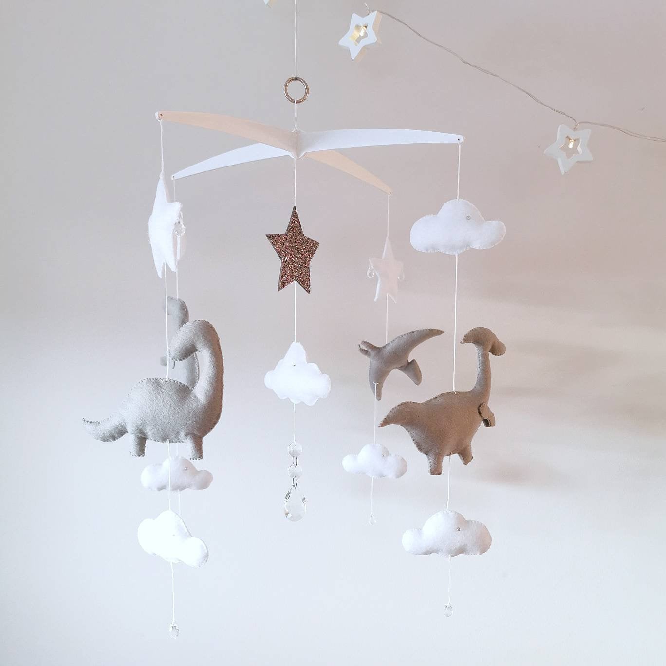 Heirloom baby mobile with delicate cloud drops, felt stars, and softly stitched dinosaurs.