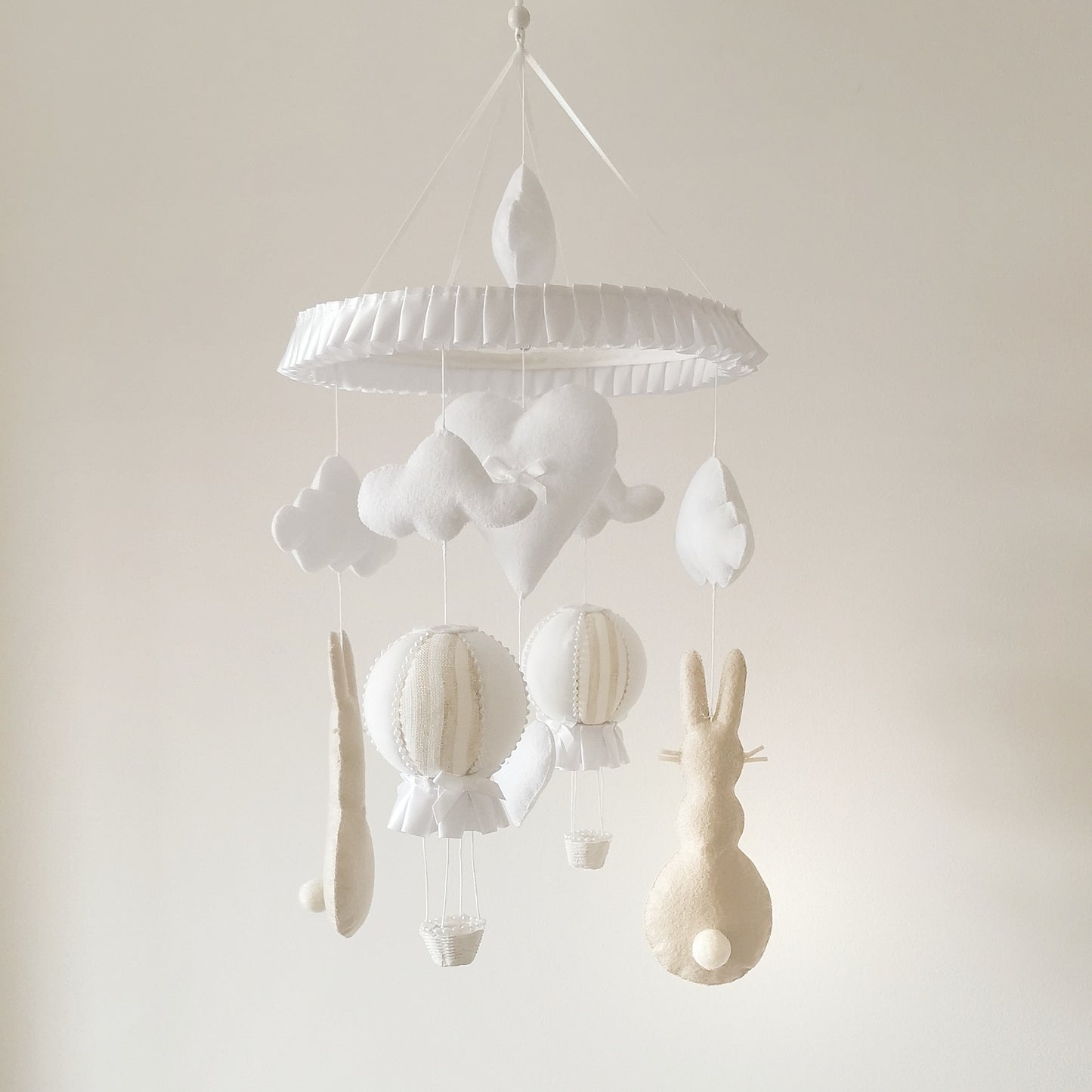 Heirloom baby mobile crafted with love—featuring felt bunnies, handmade balloons, and floating clouds in a neutral palette.