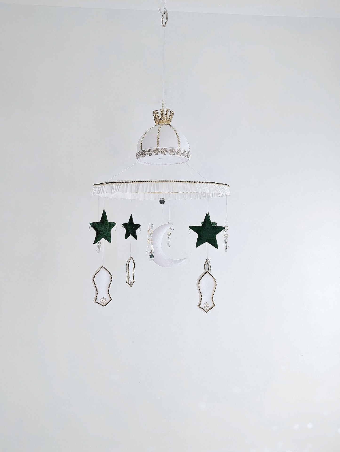 Islamic baby mobile featuring a crescent moon, green stars, and white mosque motifs, handcrafted with love for a peaceful faith-inspired nursery.