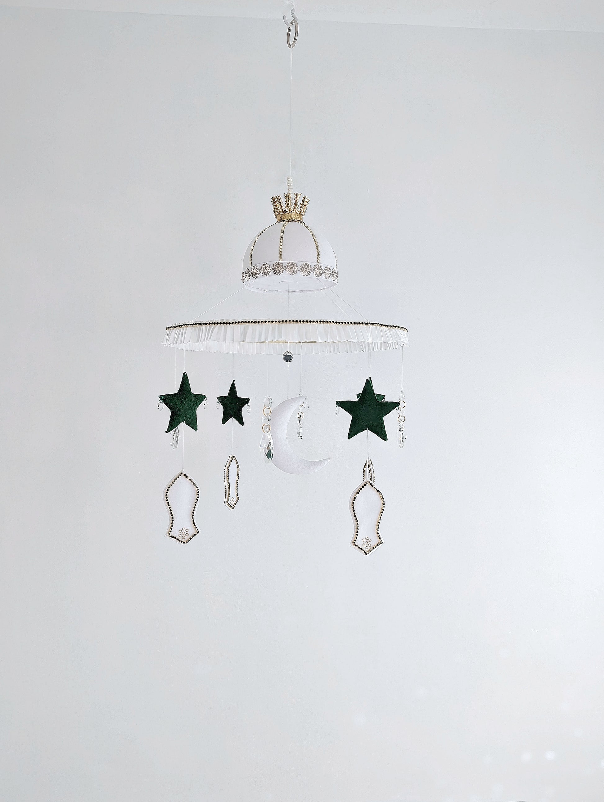 Islamic baby mobile featuring a crescent moon, green stars, and white mosque motifs, handcrafted with love for a peaceful faith-inspired nursery.
