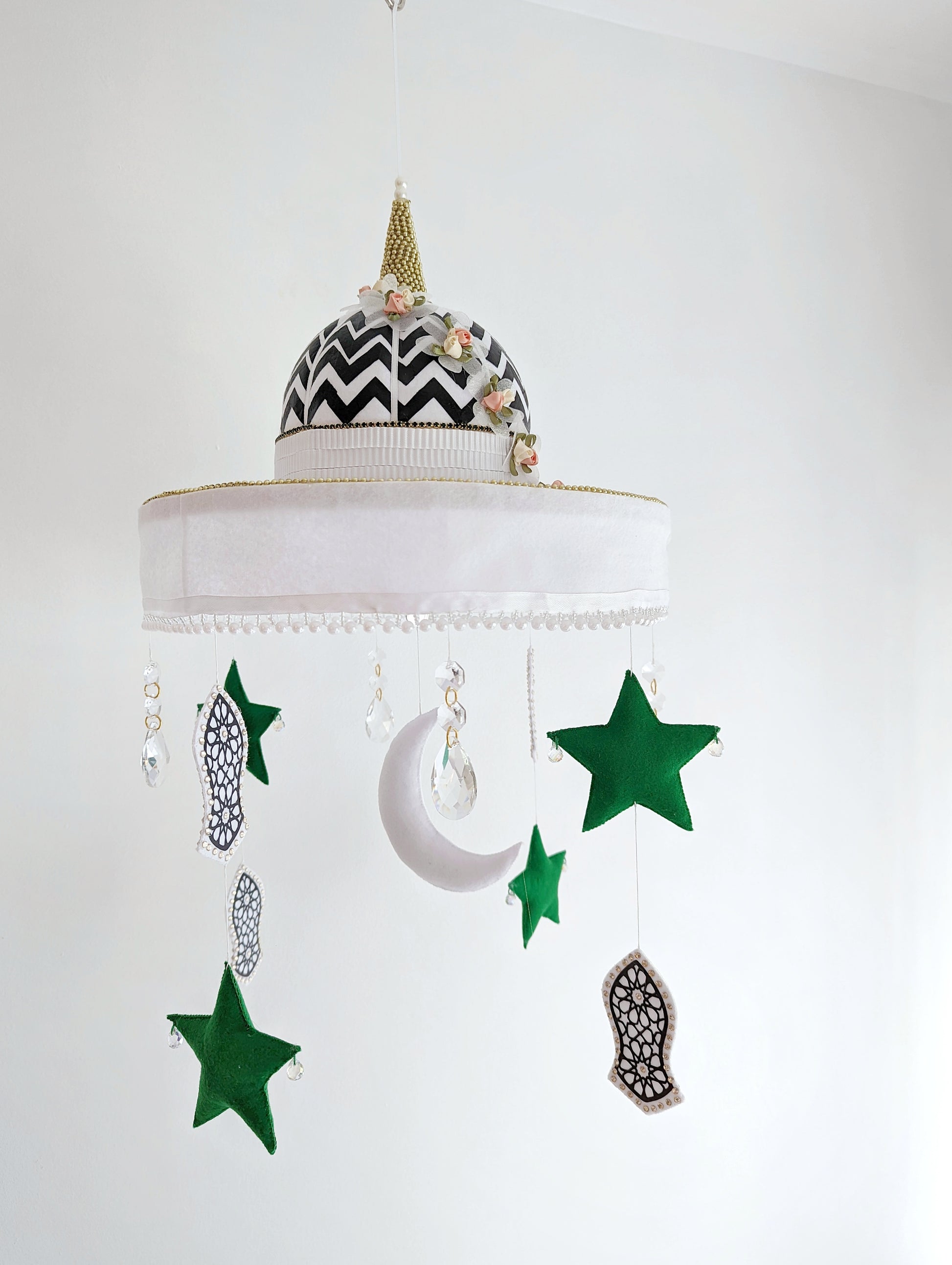 Islamic nursery mobile with green stars, crescent moon, and symbolic Sandal of the Prophet Muhammad (pbuh), set beneath a bold mosque dome.