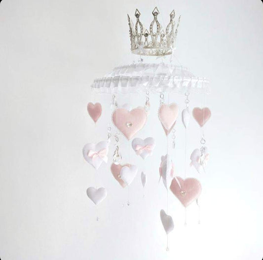 Princess-inspired baby mobile with ruffled trim, dangling hearts, and a regal crown centrepiece.