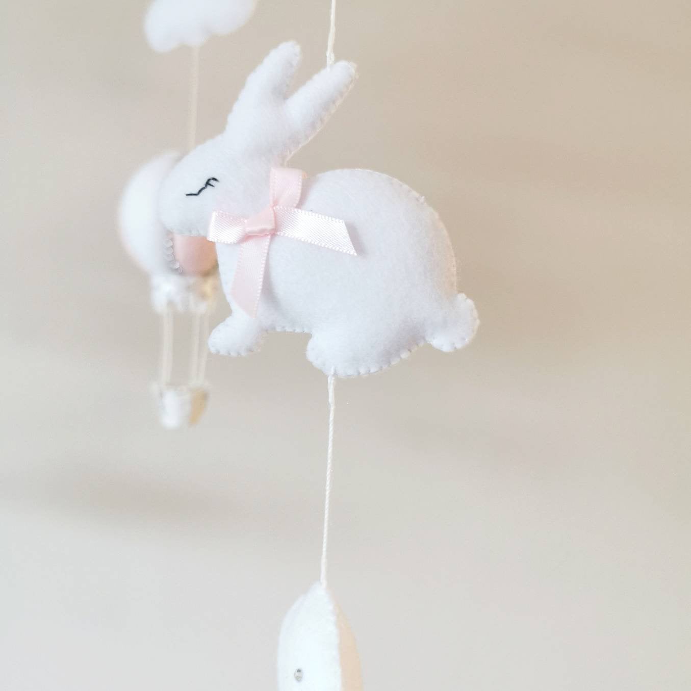 Refined and sweet baby mobile with  handcrafted sleepy bunnies, soft clouds, and blush hot air balloon.