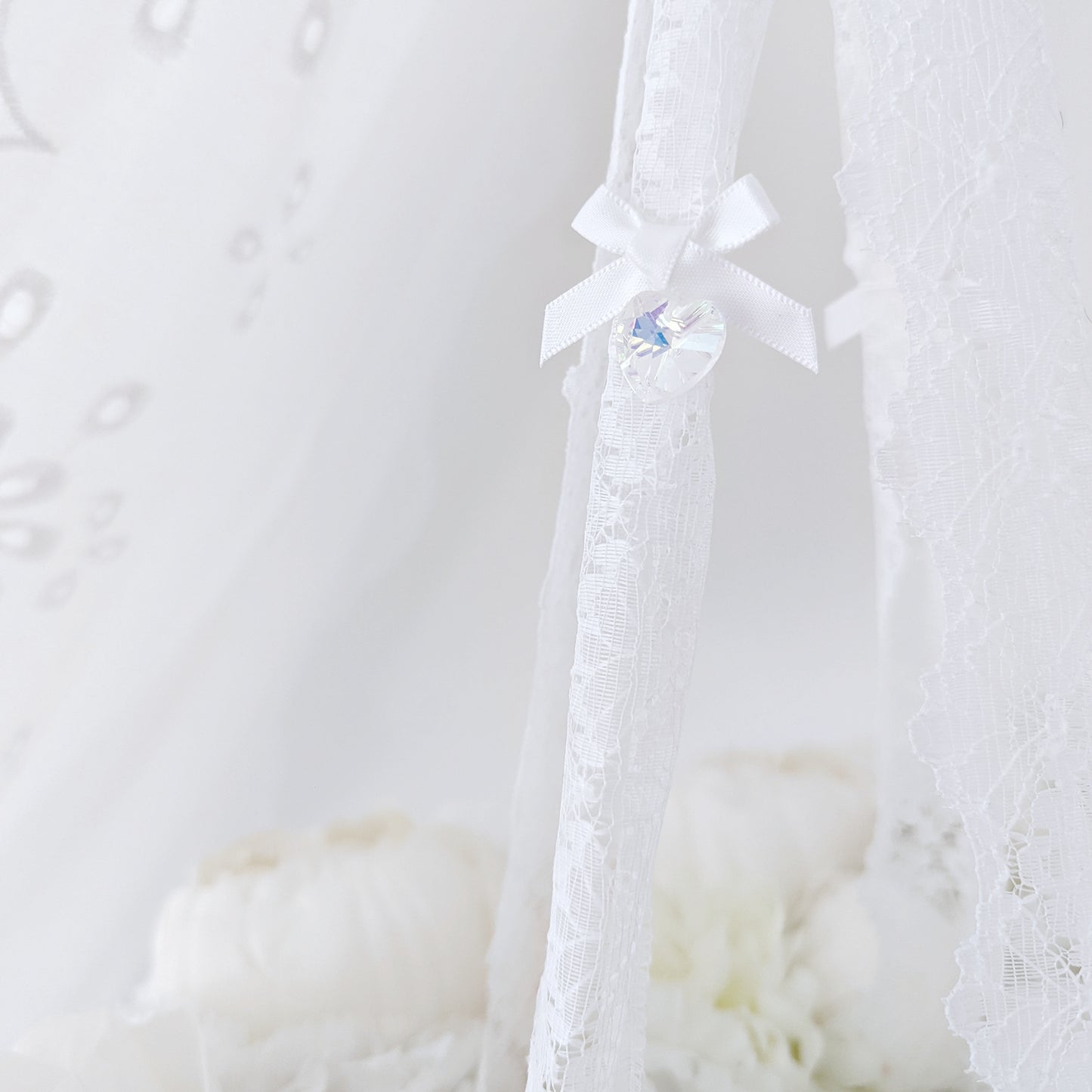 Close-up of soft blush and ivory florals forming a delicate wreath, part of a high-end baby mobile.
