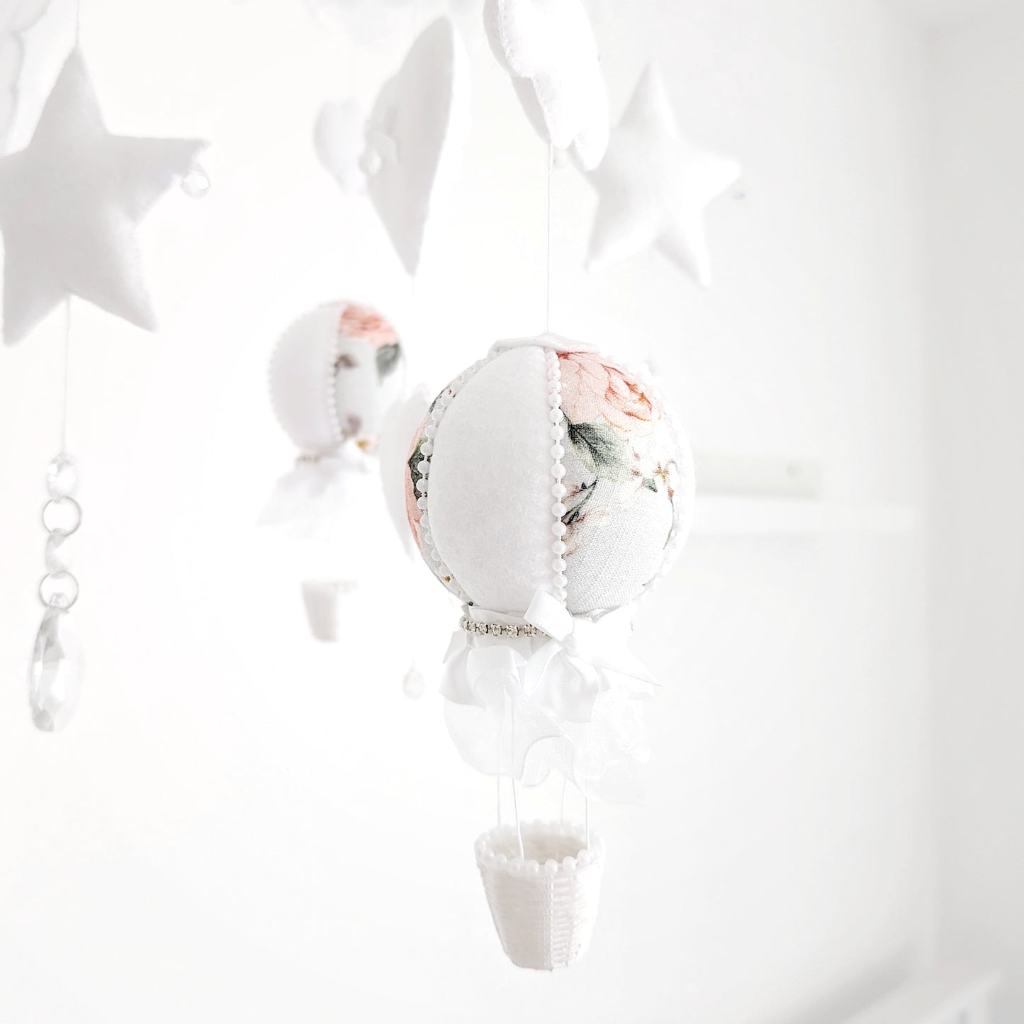 Handcrafted luxury baby mobile featuring floral balloons, clouds, and sparkling details on a round canopy-style frame.