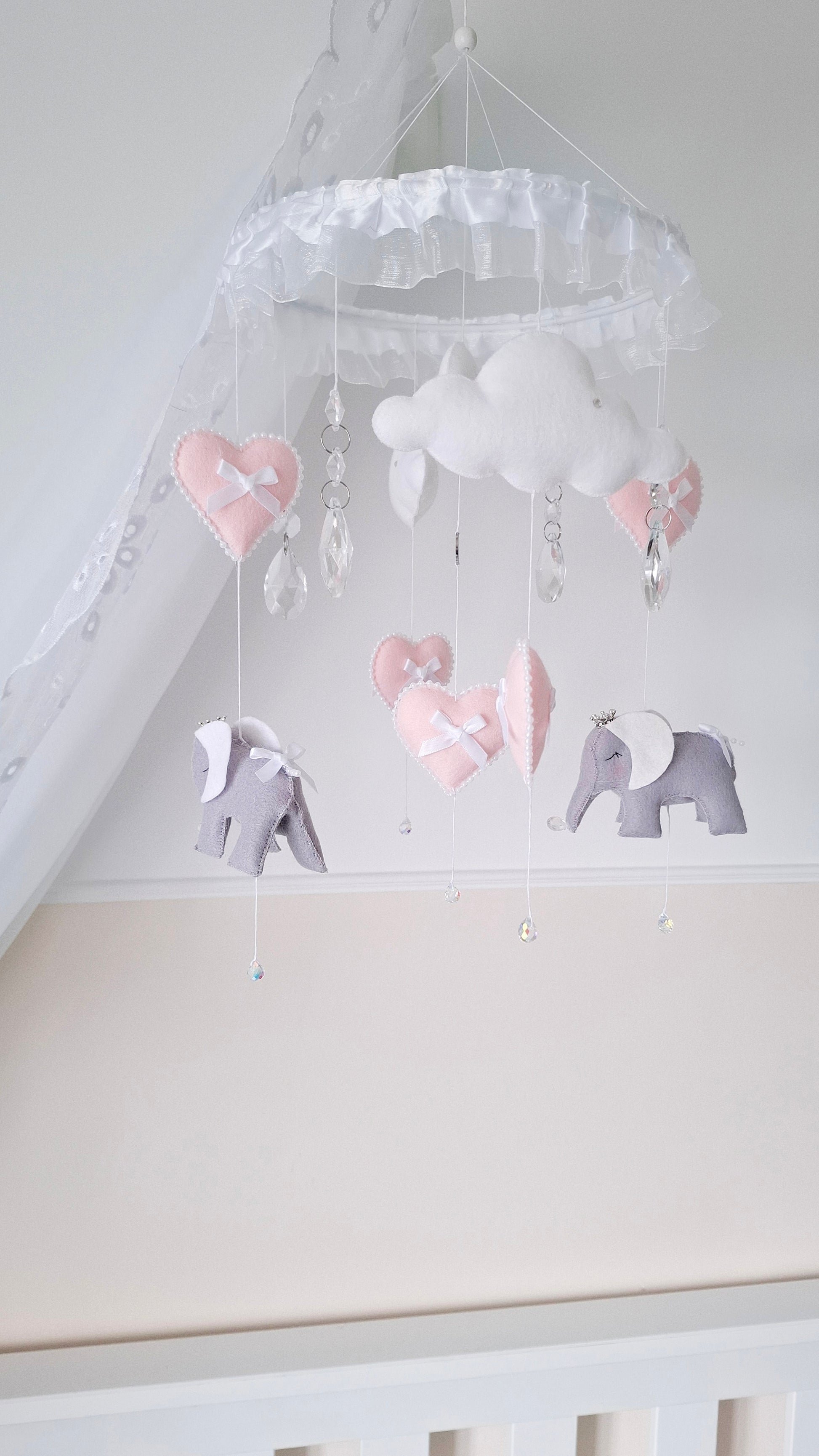 Elegant pink and grey elephant crib mobile with heart charms and handcrafted details, perfect for a soft-toned nursery.