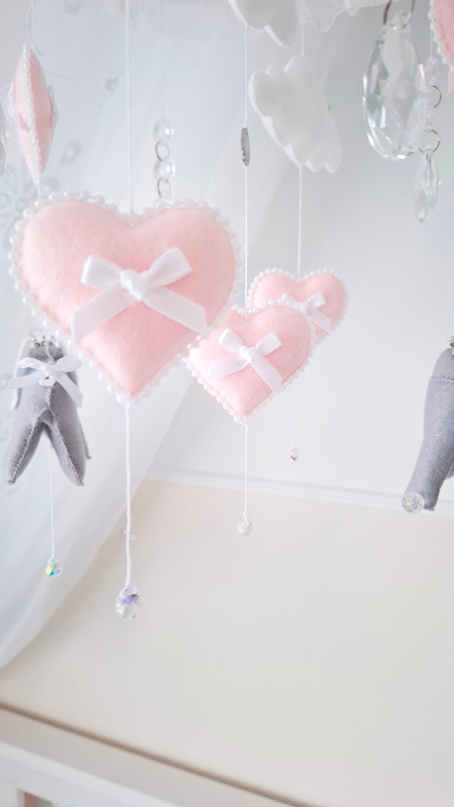 Grey felt elephants and pink hearts mobile with crystal accents, designed to bring calm and cuteness to a baby’s nursery.