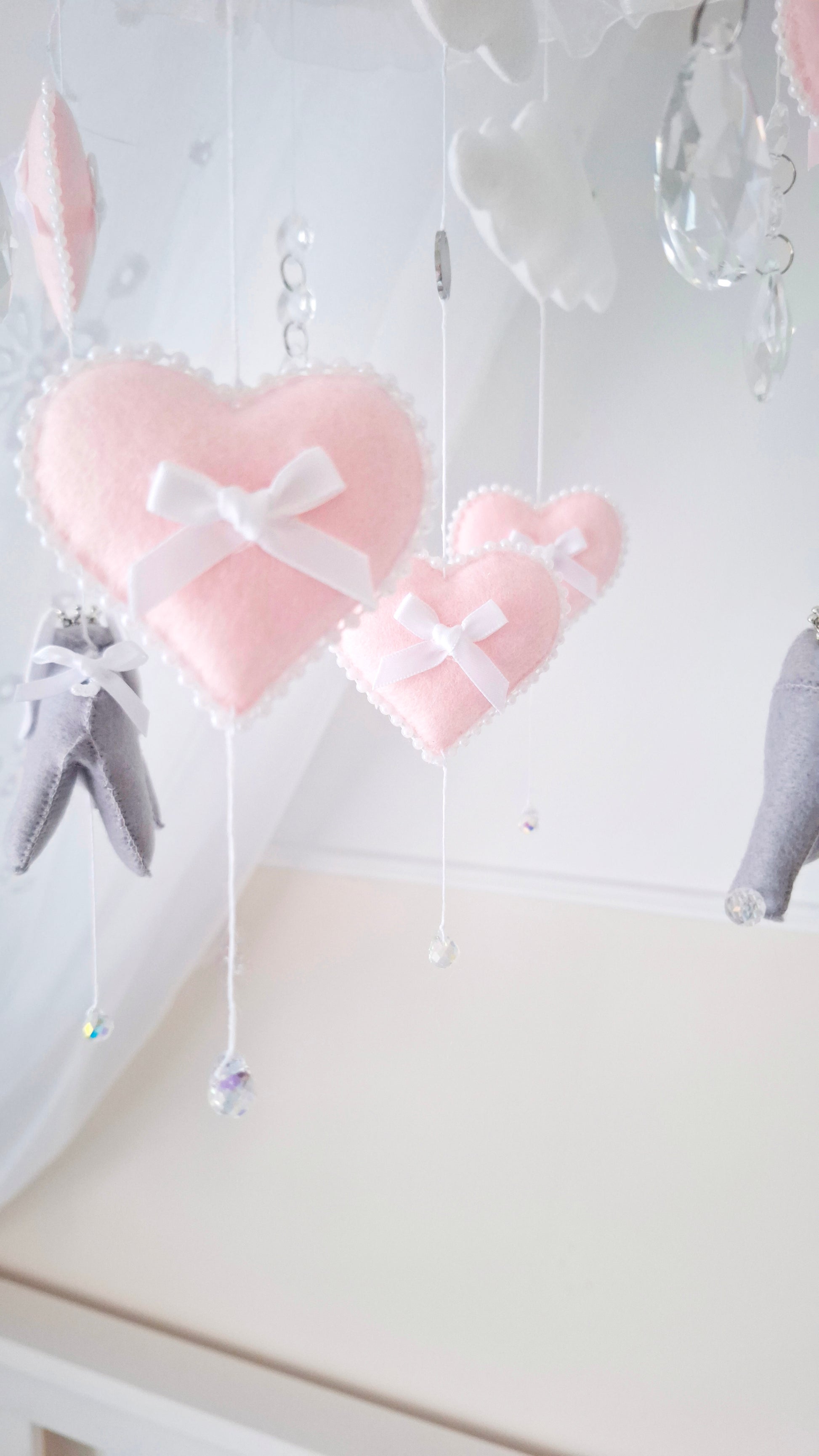 Grey felt elephants and pink hearts mobile with crystal accents, designed to bring calm and cuteness to a baby’s nursery.