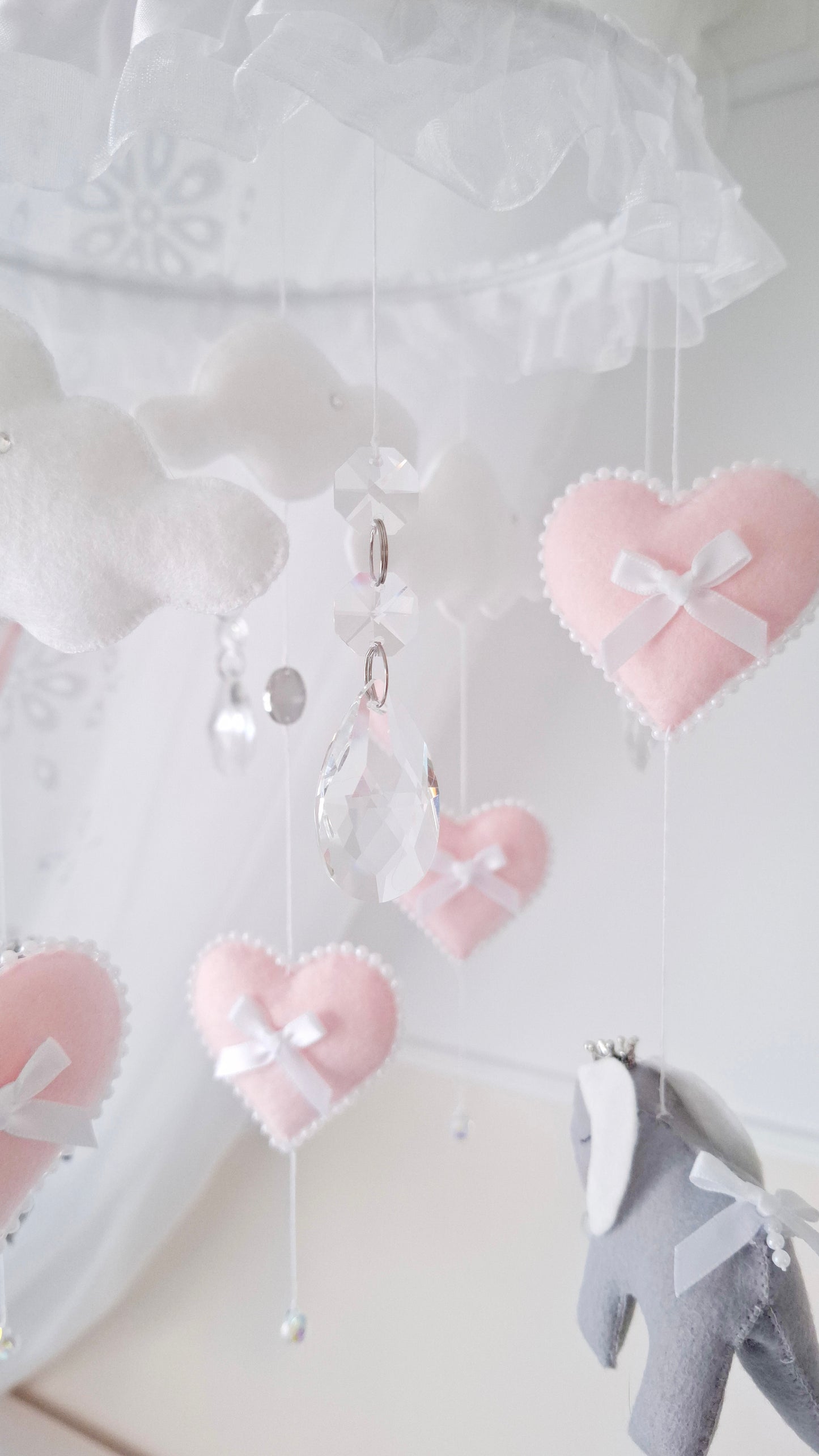 Handmade elephant mobile featuring pale pink hearts with bows and soft felt elephants in gentle lilac grey tones.