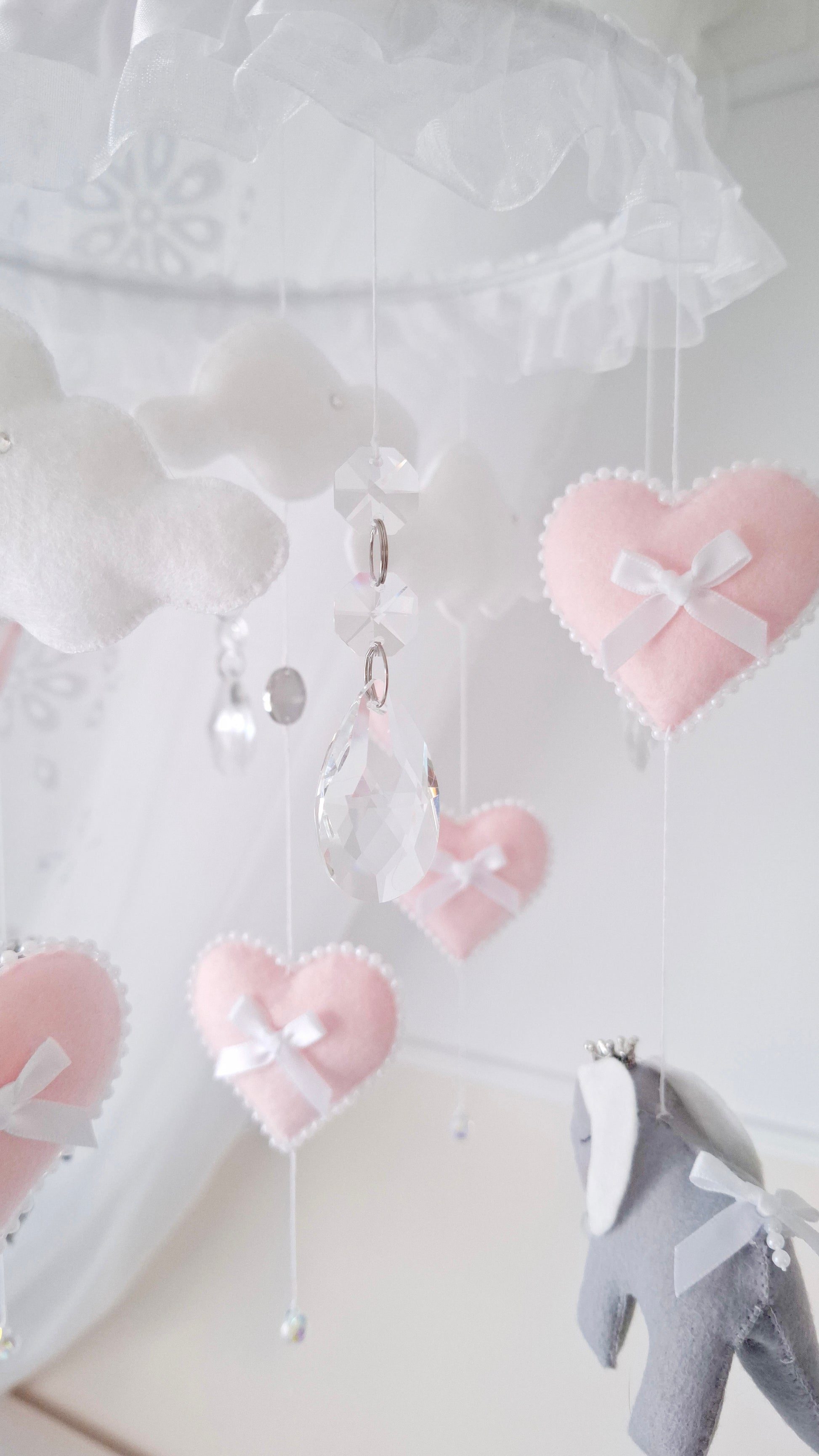 Handmade elephant mobile featuring pale pink hearts with bows and soft felt elephants in gentle lilac grey tones.