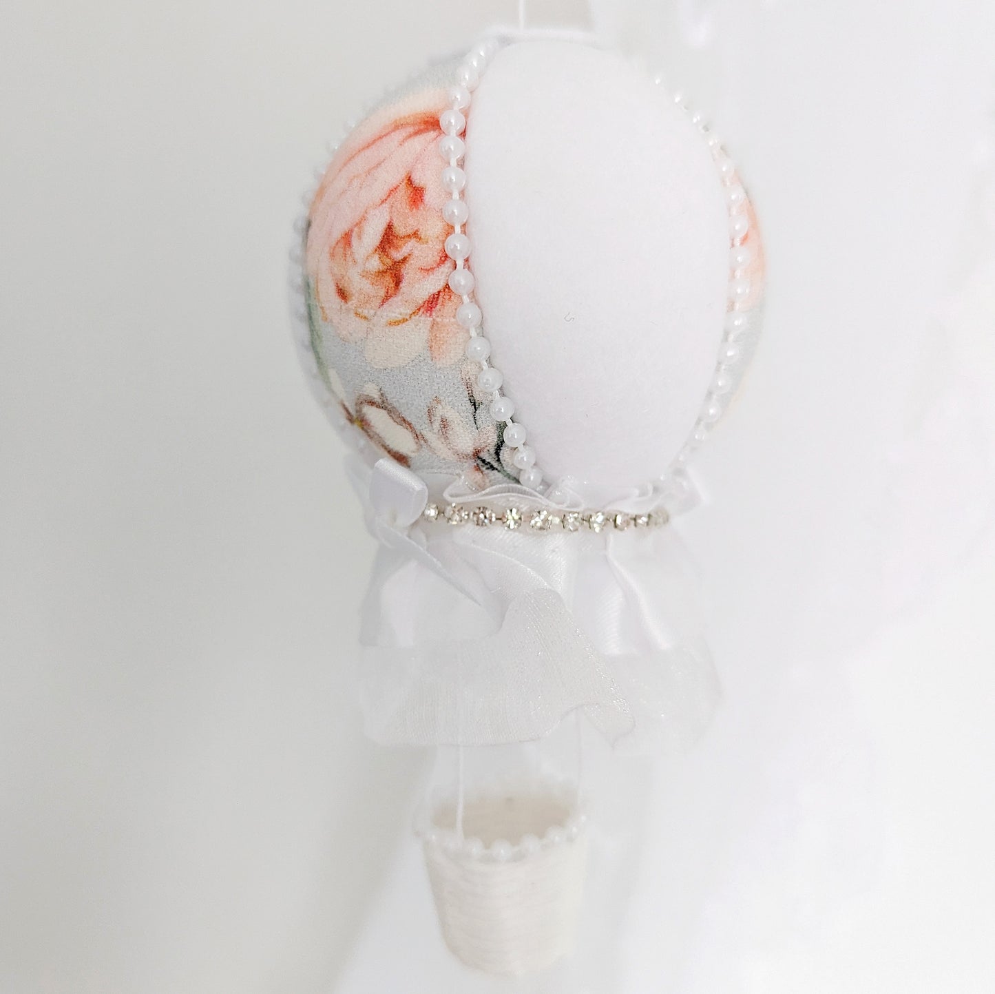 Close up of handcrafted luxury balloon with soft rose print and pearl detail