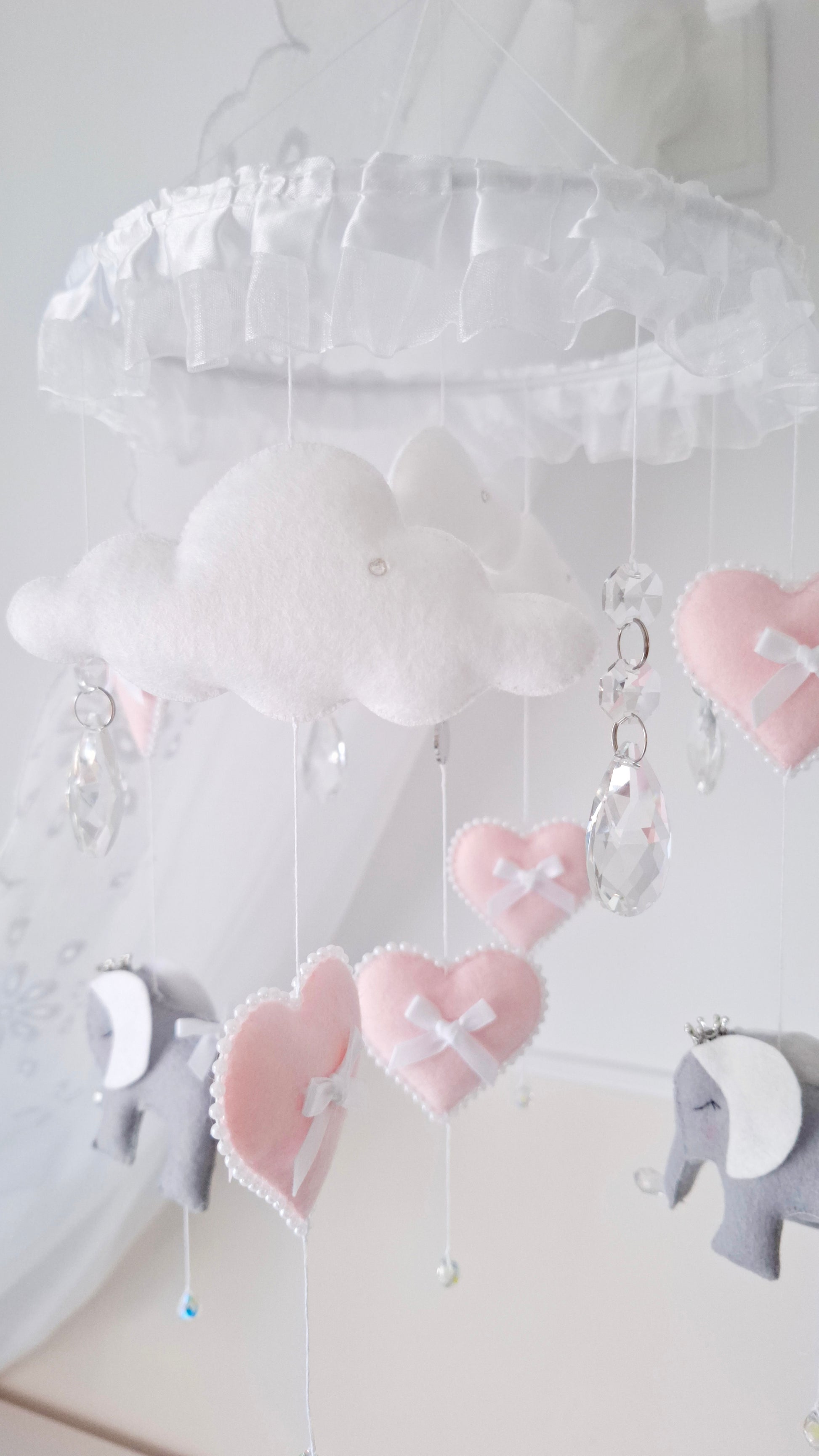 Pastel elephant mobile with soft pink and white heart decorations and a delicate handmade touch.

