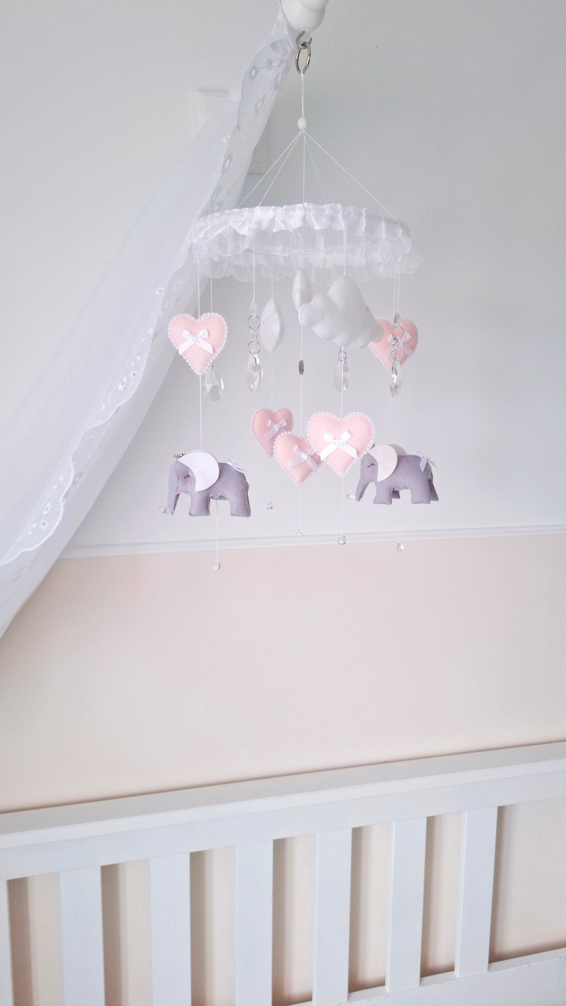 Soft pink and grey elephant baby mobile with heart details and crystal drops, perfect for a delicate nursery theme.