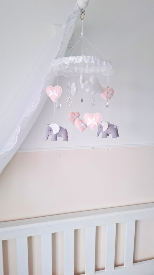 Soft pink and grey elephant baby mobile with heart details and crystal drops, perfect for a delicate nursery theme.