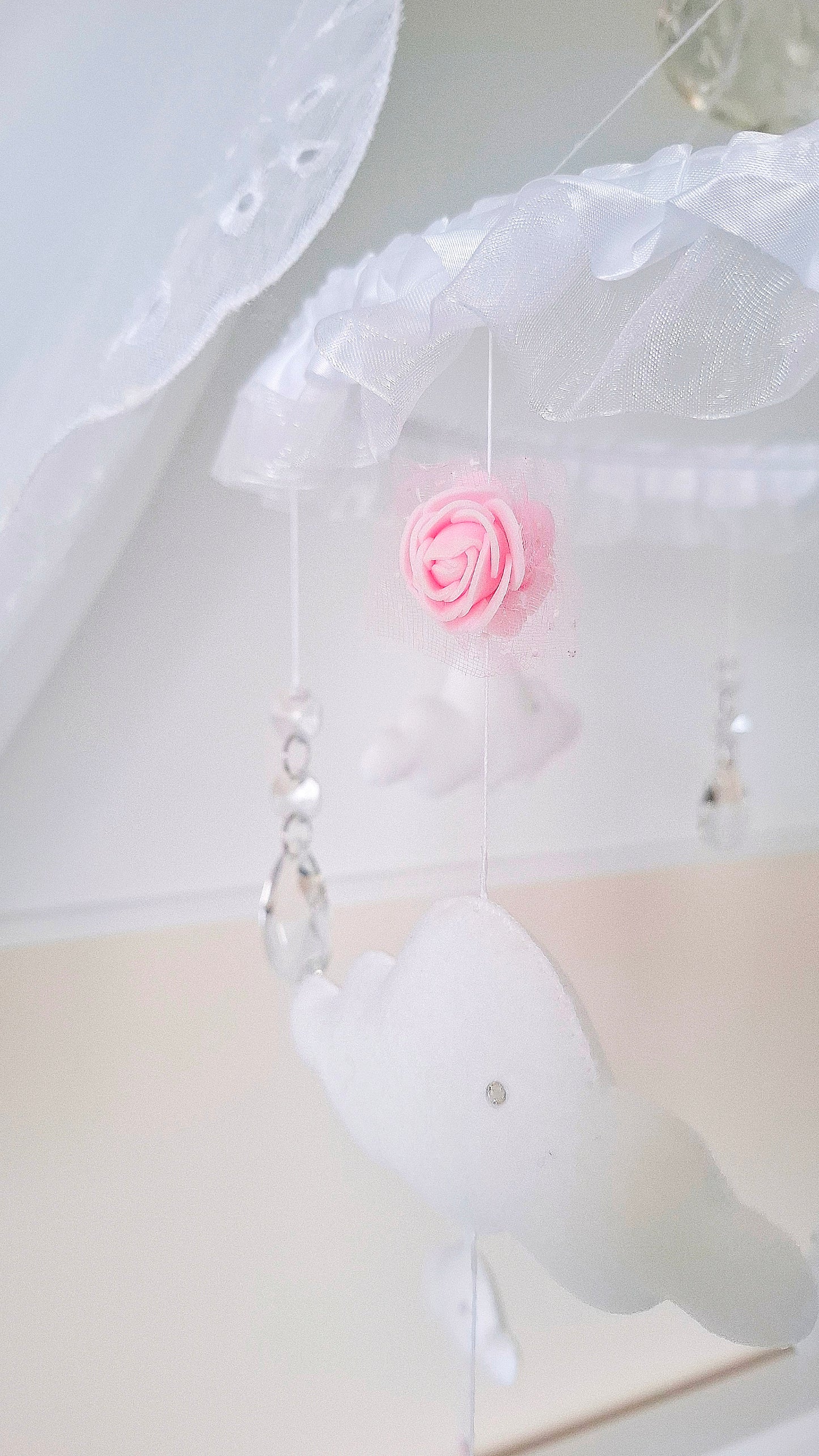 Princess-inspired nursery mobile with a silver tiara crown, delicate clouds, and pink heart charms for a whimsical touch.

