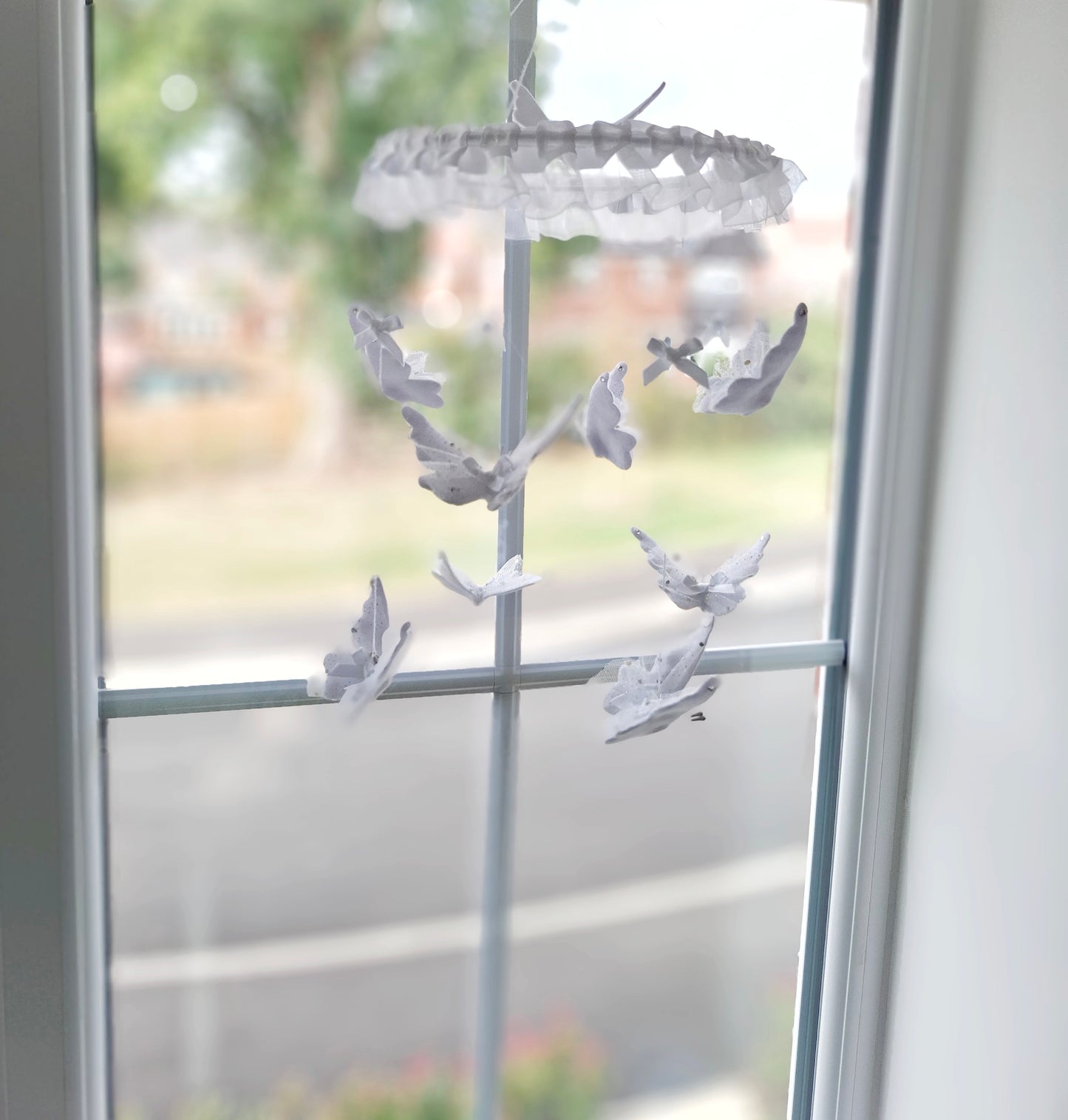 Pure white baby mobile with fluttering butterflies, crafted with love to bring quiet beauty and soft movement to the nursery.


