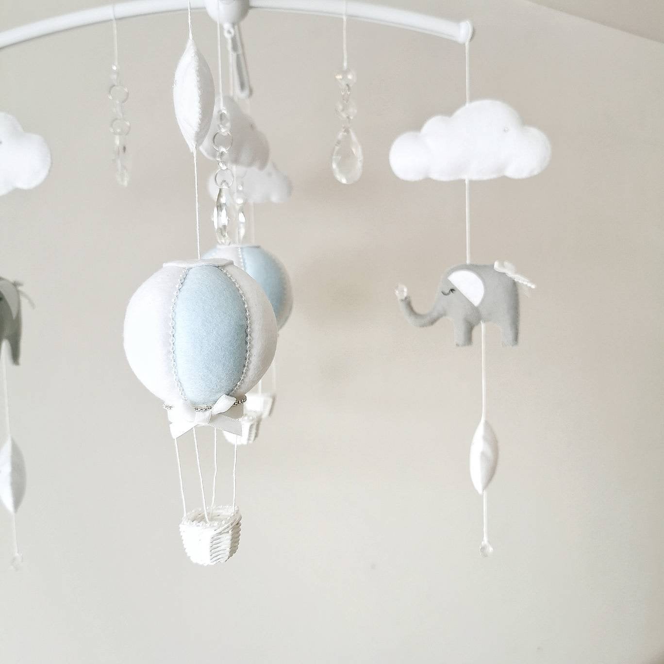 A gentle mobile in soft blue and white tones styled for a baby boy’s nursery perfect for gifting or adding quiet charm