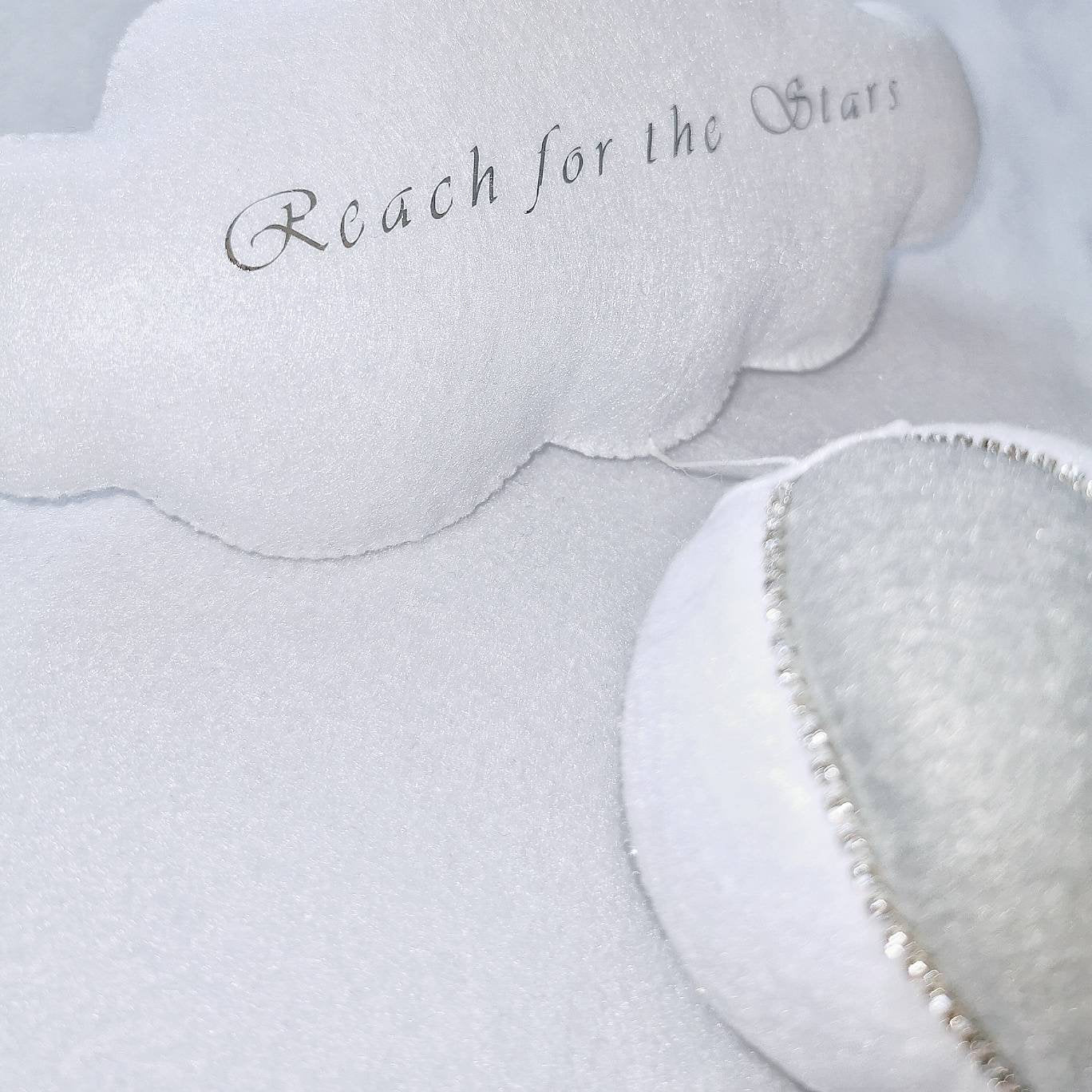 Close-up of handmade felt textures on a white and grey nursery balloon with embroidered cloud accent.