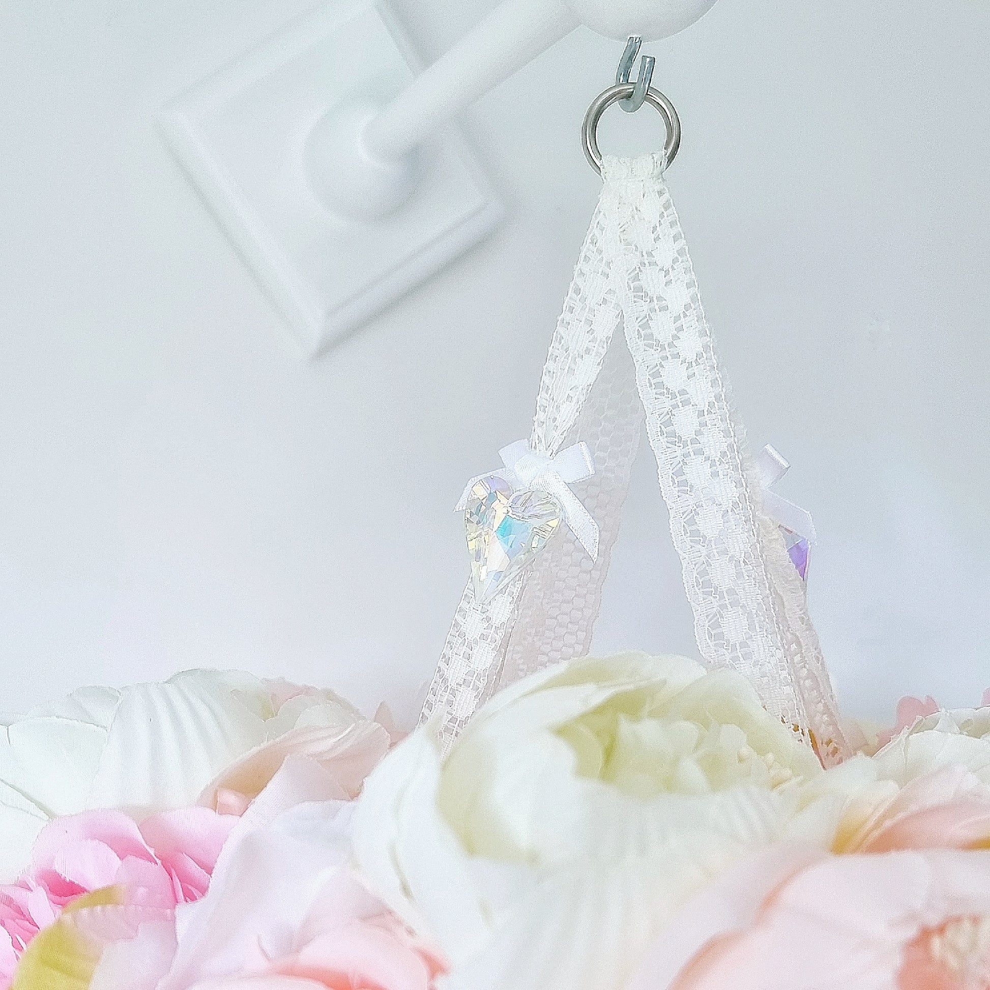Dreamy mobile featuring a blush butterfly and delicate pink roses beneath a crown of mixed faux florals.
