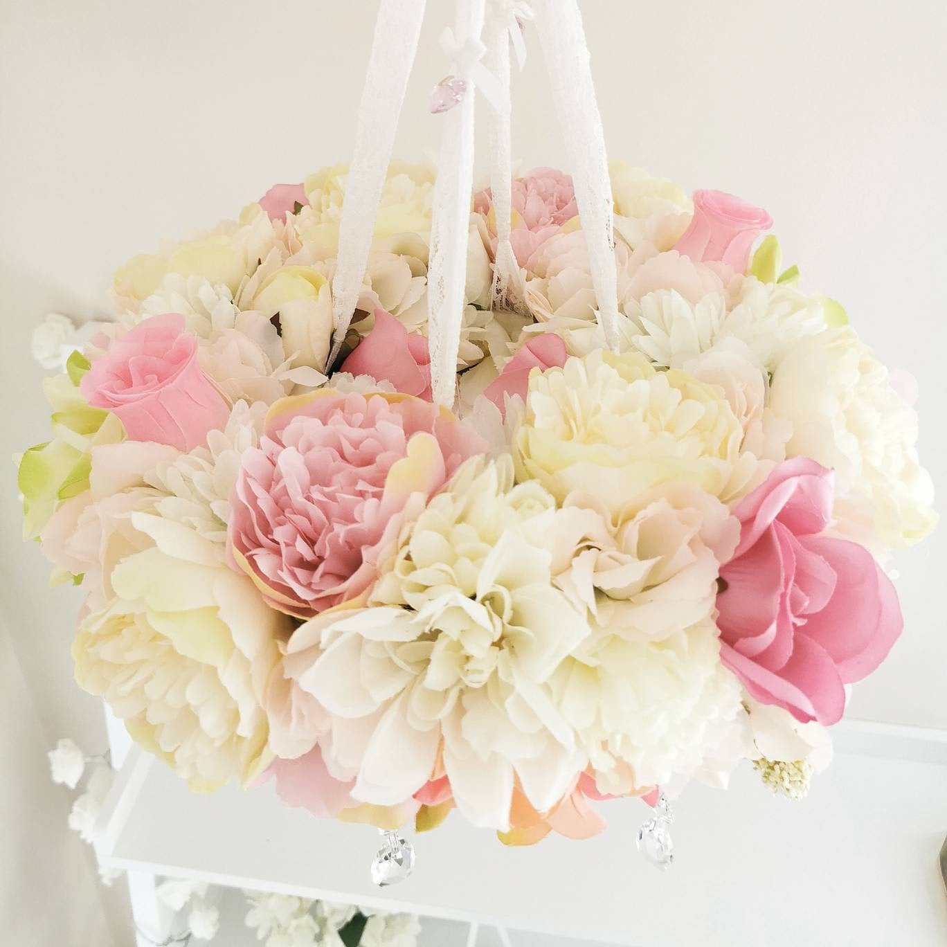 Hanging floral mobile with a handcrafted blush hot air balloon, delicate roses, and floating crystal drops.