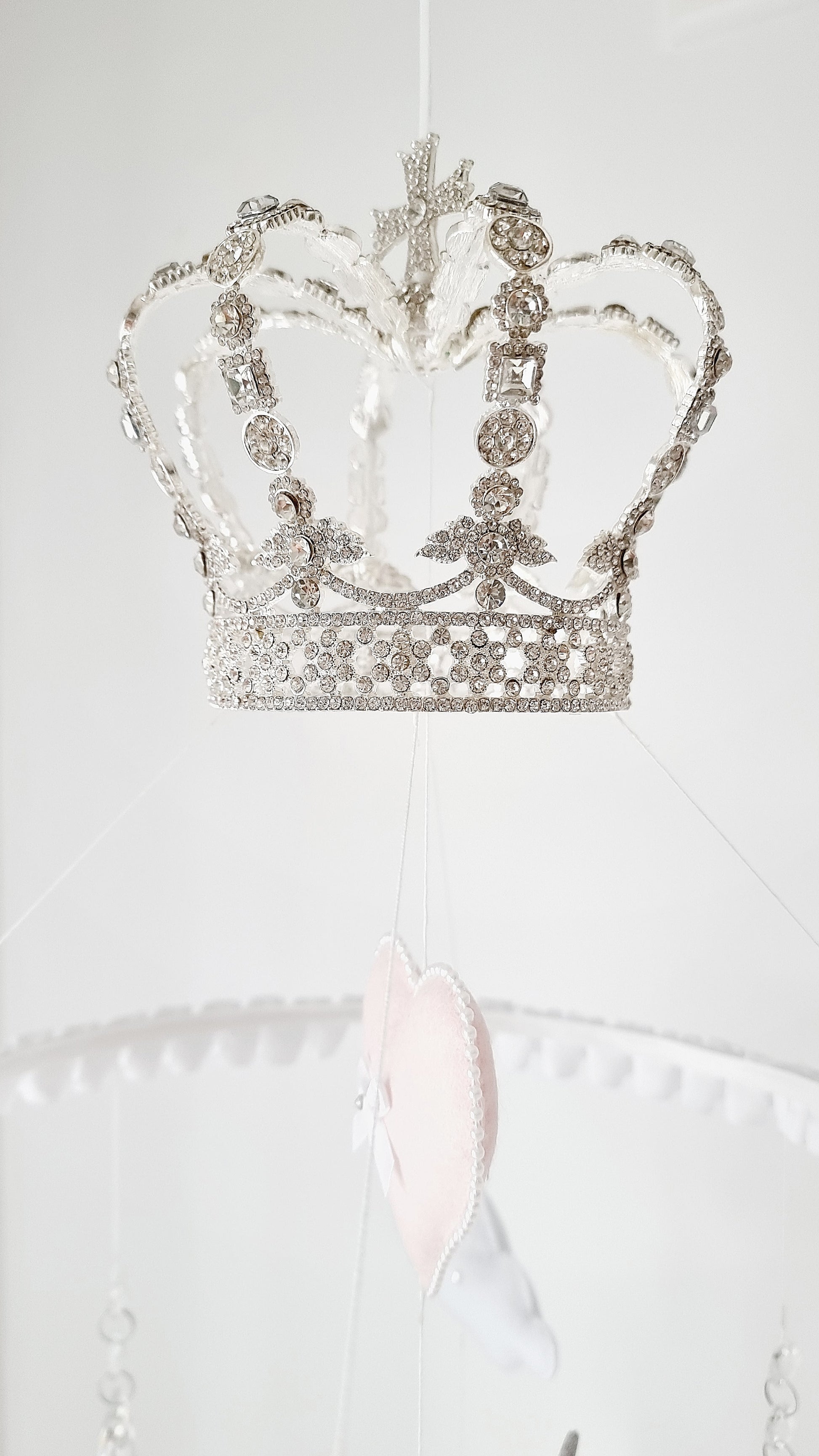 Blush pink and white unicorn mobile with crystal drops, ruffled accents, and a regal crown for the most enchanting nursery setting.

