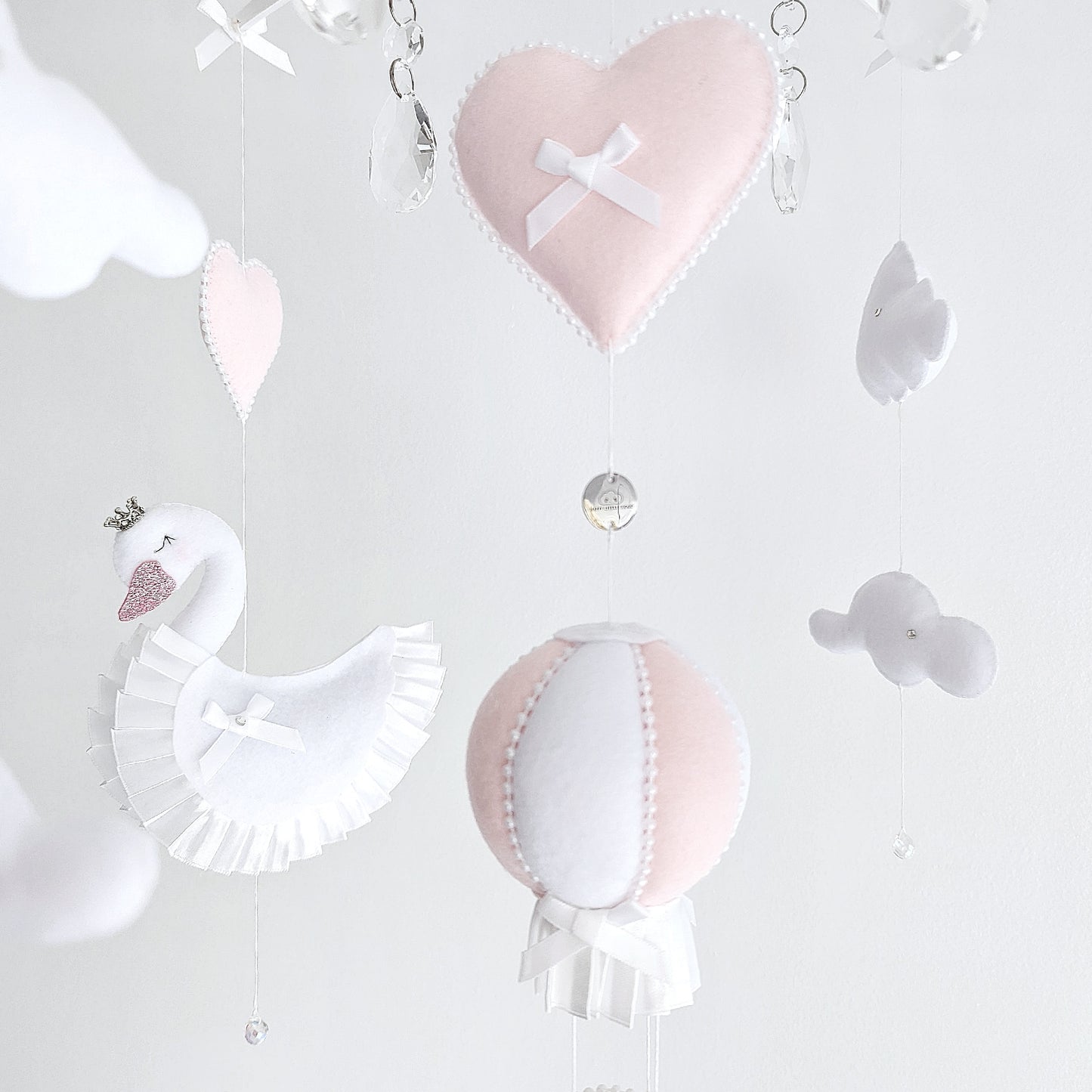 Boutique handmade baby mobile with swans and soft blush accents, a timeless nursery gift.