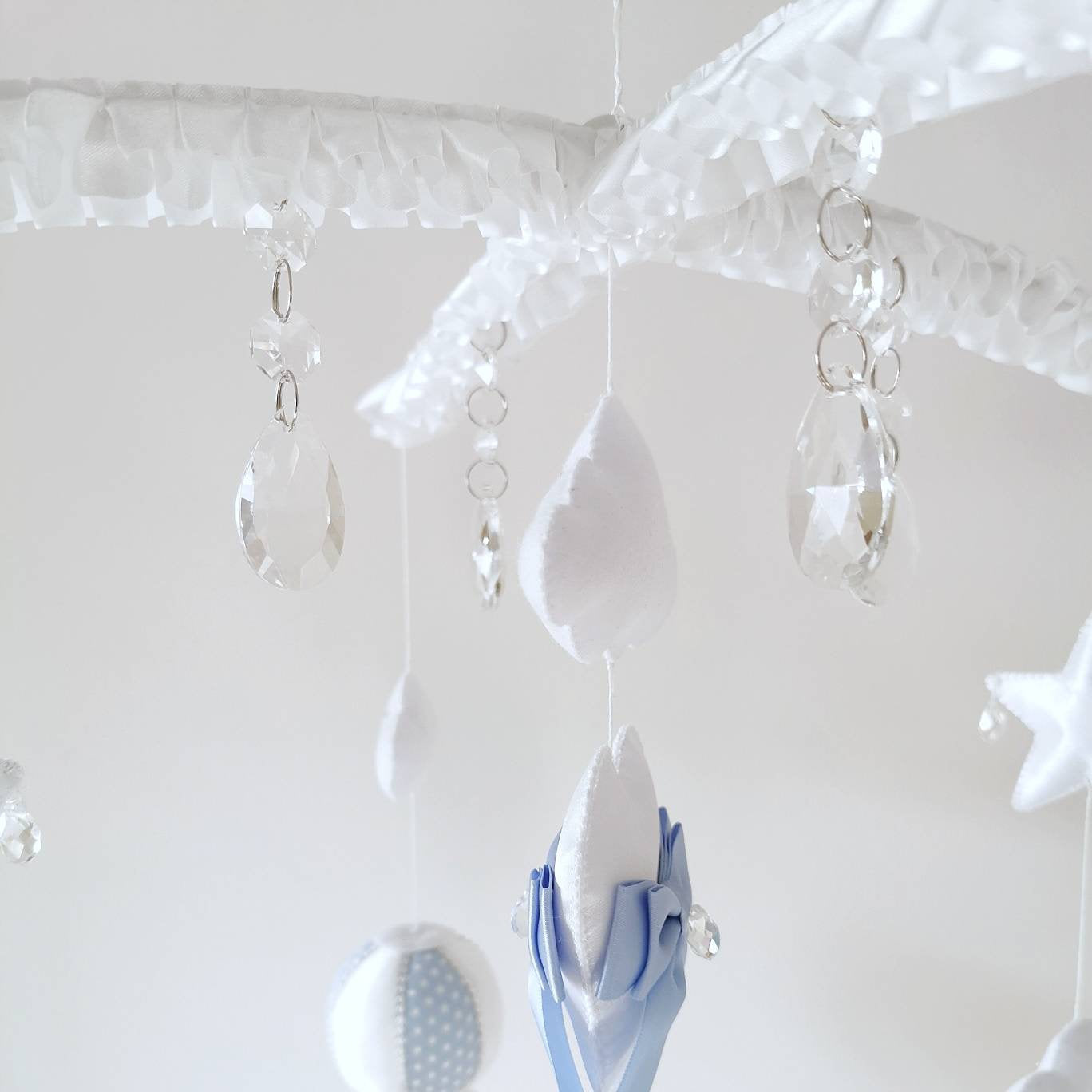 Overhead layout showing felt stars, clouds, and balloon elements for a handmade nursery mobile.