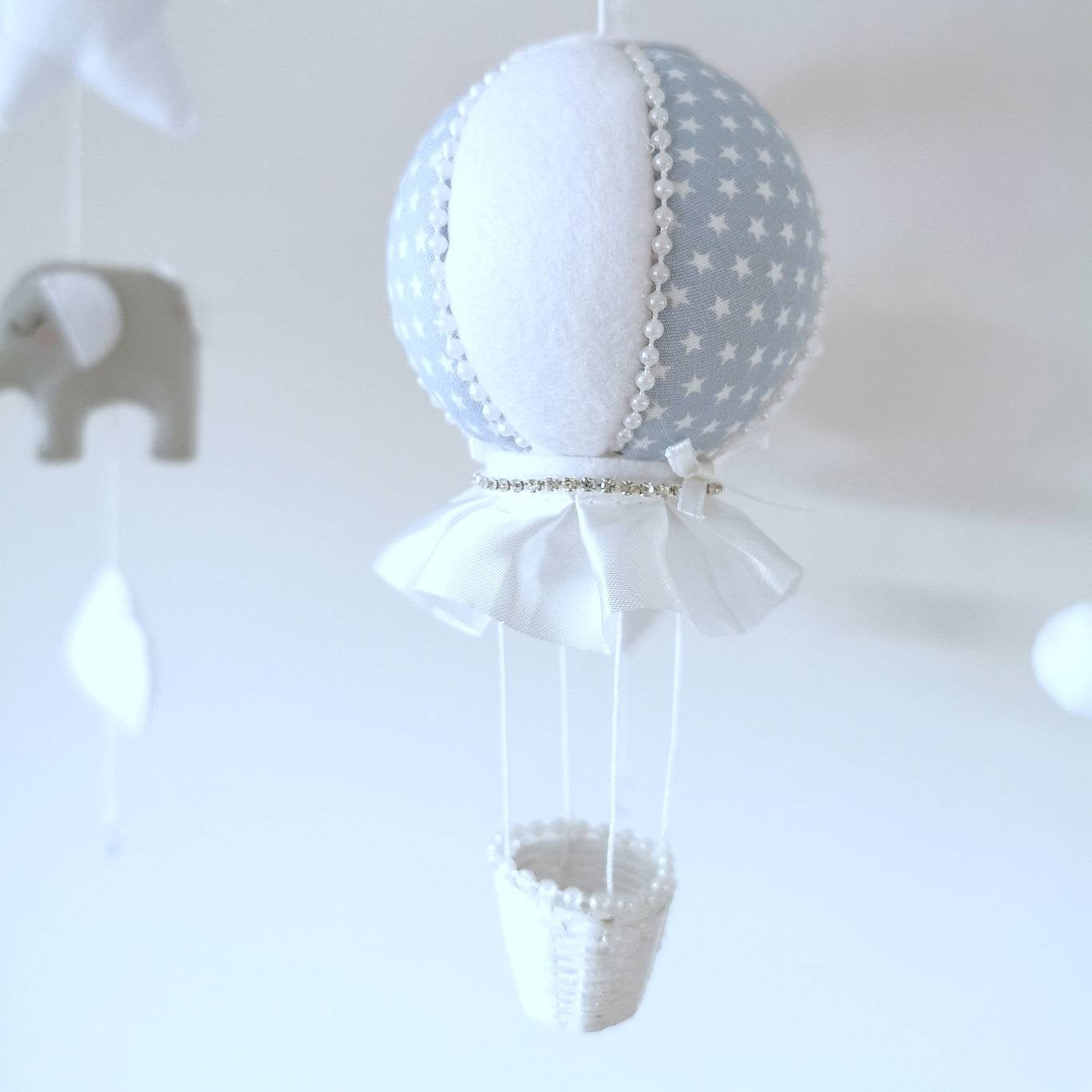 A luxury hot air balloon with crystal trimming and satin details. Pale blue with stars and white. Perfect addition for a elegant baby boy nursery