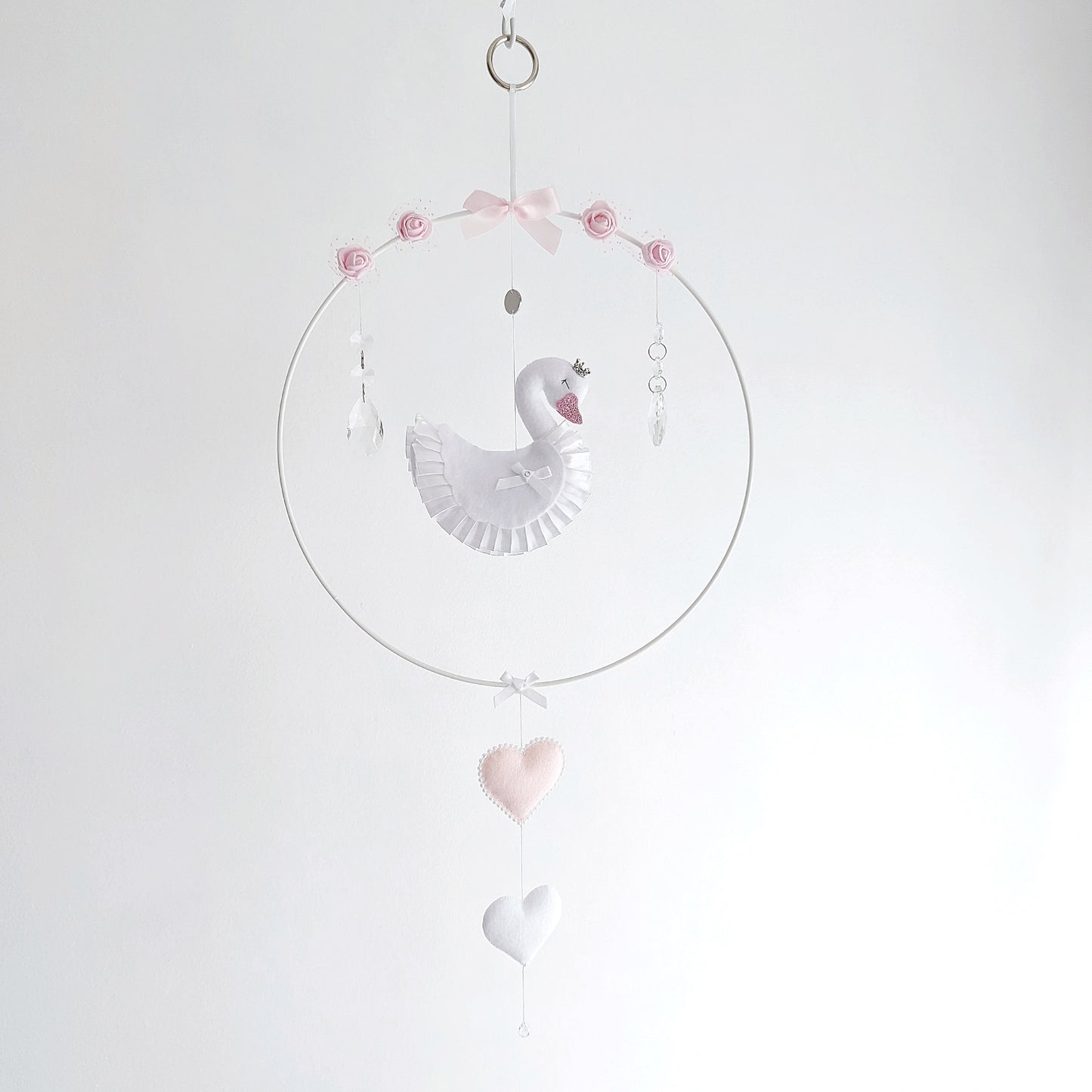 Curated swan wall charm in soft pink and white, featuring a crown, roses, and delicate hanging hearts.