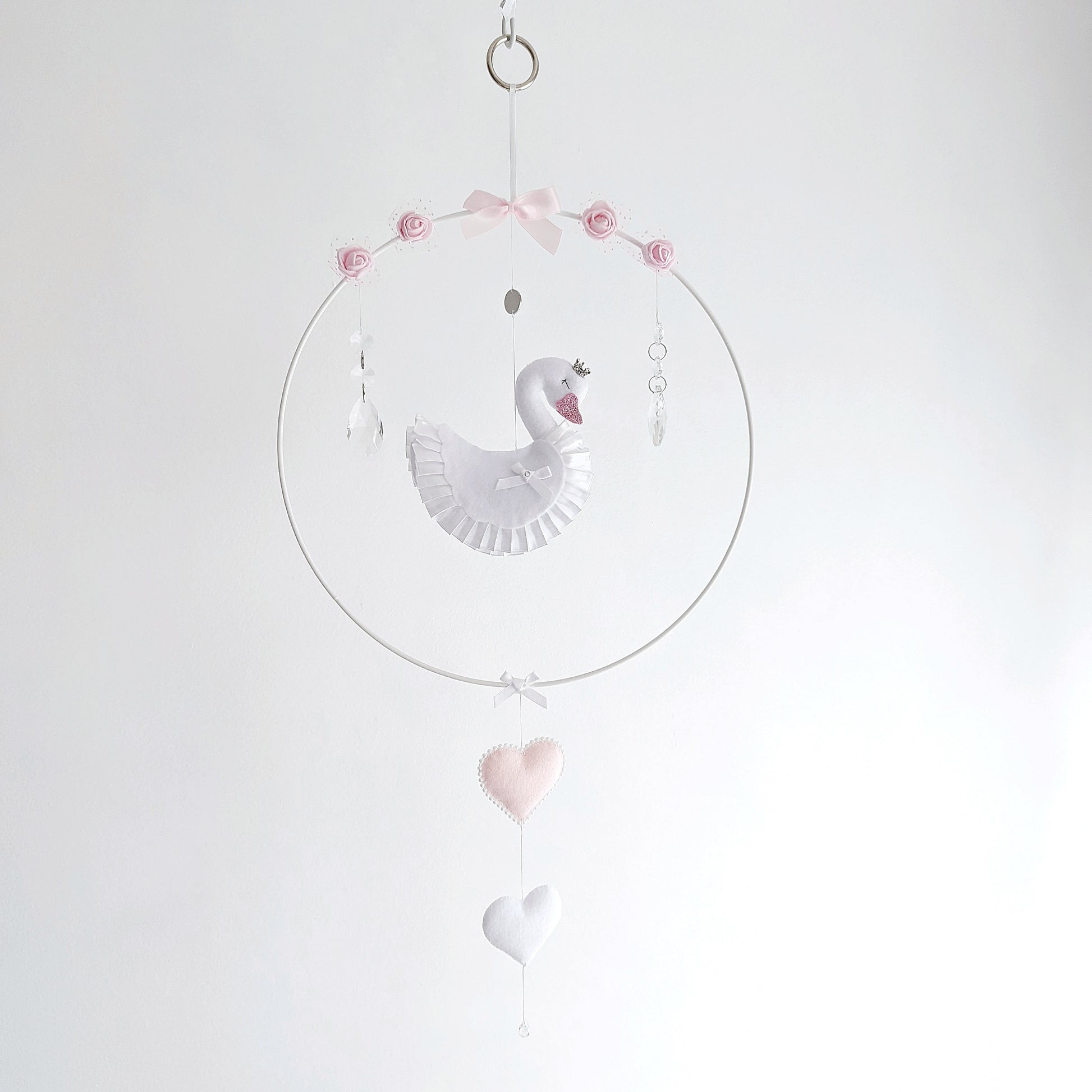Curated swan wall charm in soft pink and white, featuring a crown, roses, and delicate hanging hearts.
