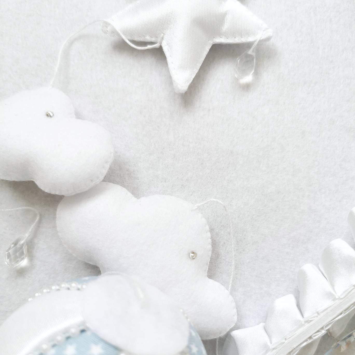 textured close up of handmade white clouds and star elements for a calming baby mobile.