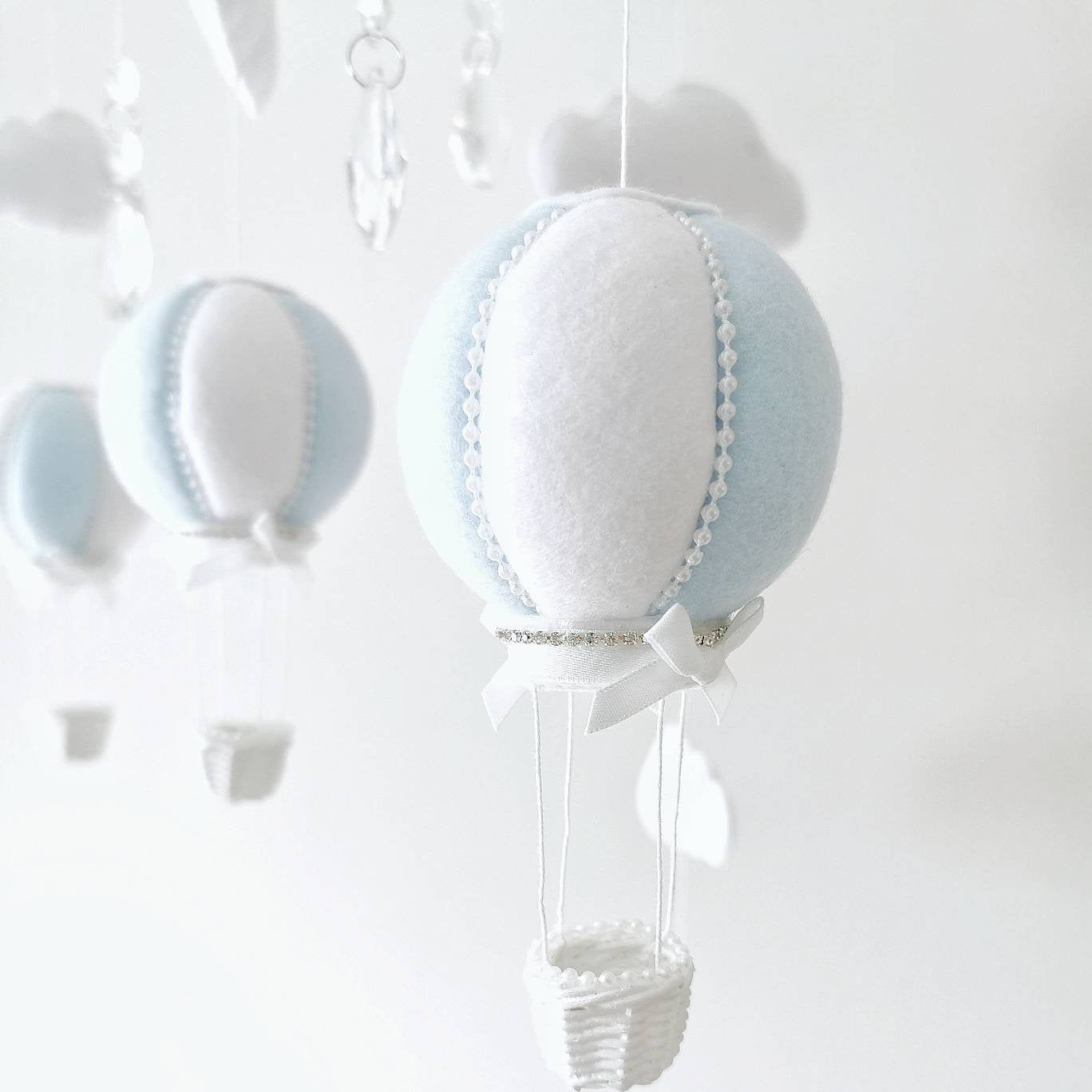 Close-up of a softly stitched light blue felt balloon with delicate detail made for quiet luxury in a baby’s room