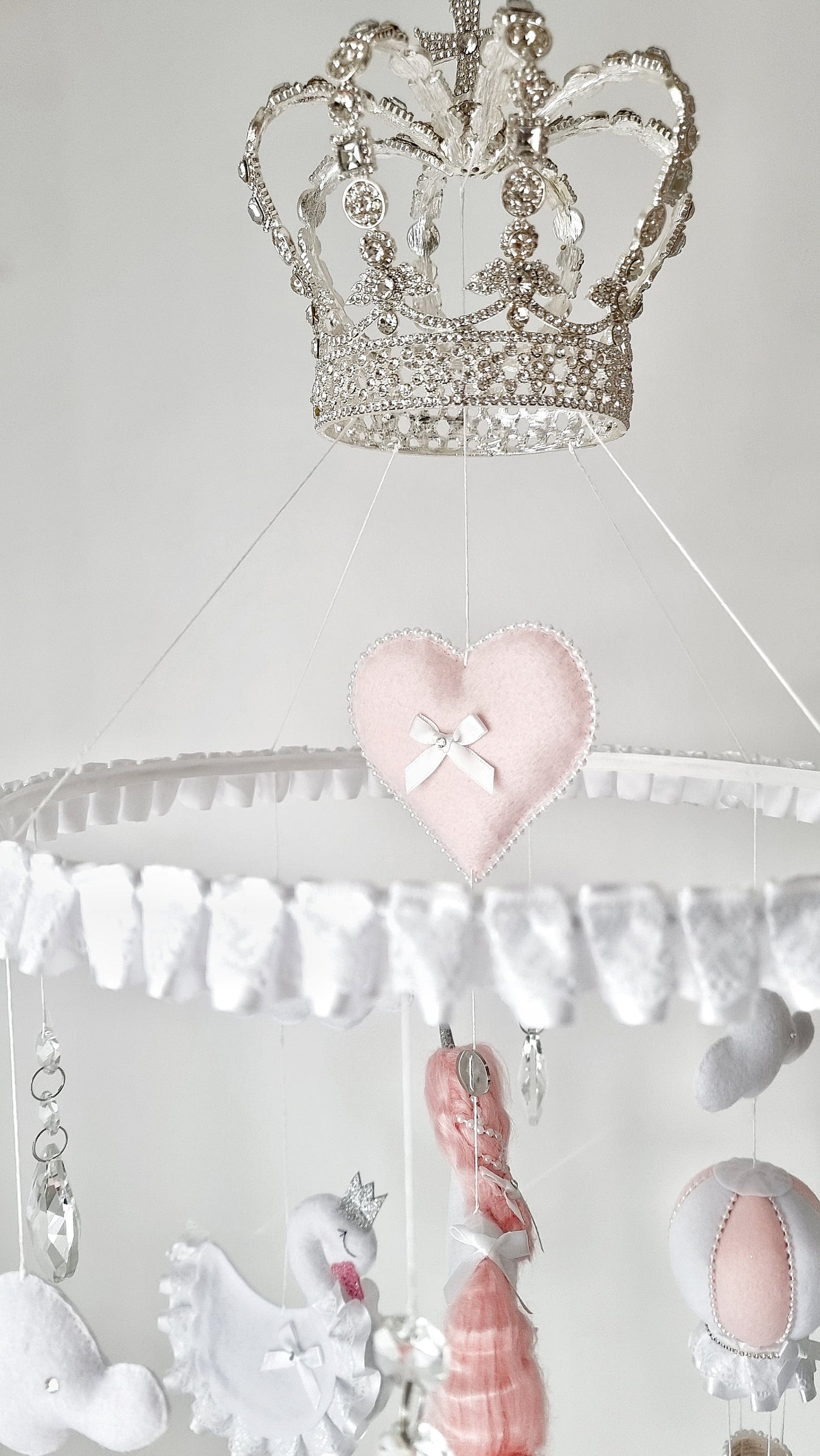 Handcrafted nursery mobile with unicorns, hot air balloons, and soft clouds, finished with shimmering details and gentle pastel tones.