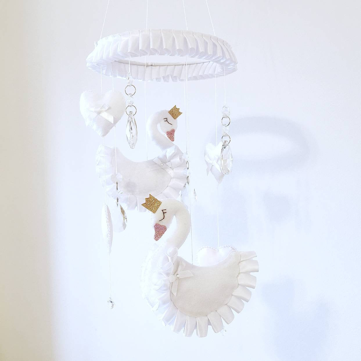 Handmade swan nursery mobile in soft pastels, featuring graceful swans with golden crowns and delicate hanging crystals.