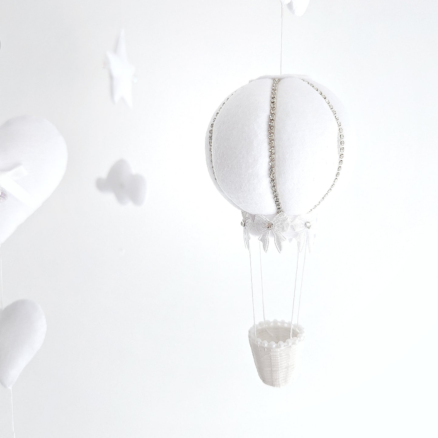 Neutral-toned baby mobile with soft hot air balloons and delicate felt clouds, ideal for a luxury unisex nursery.