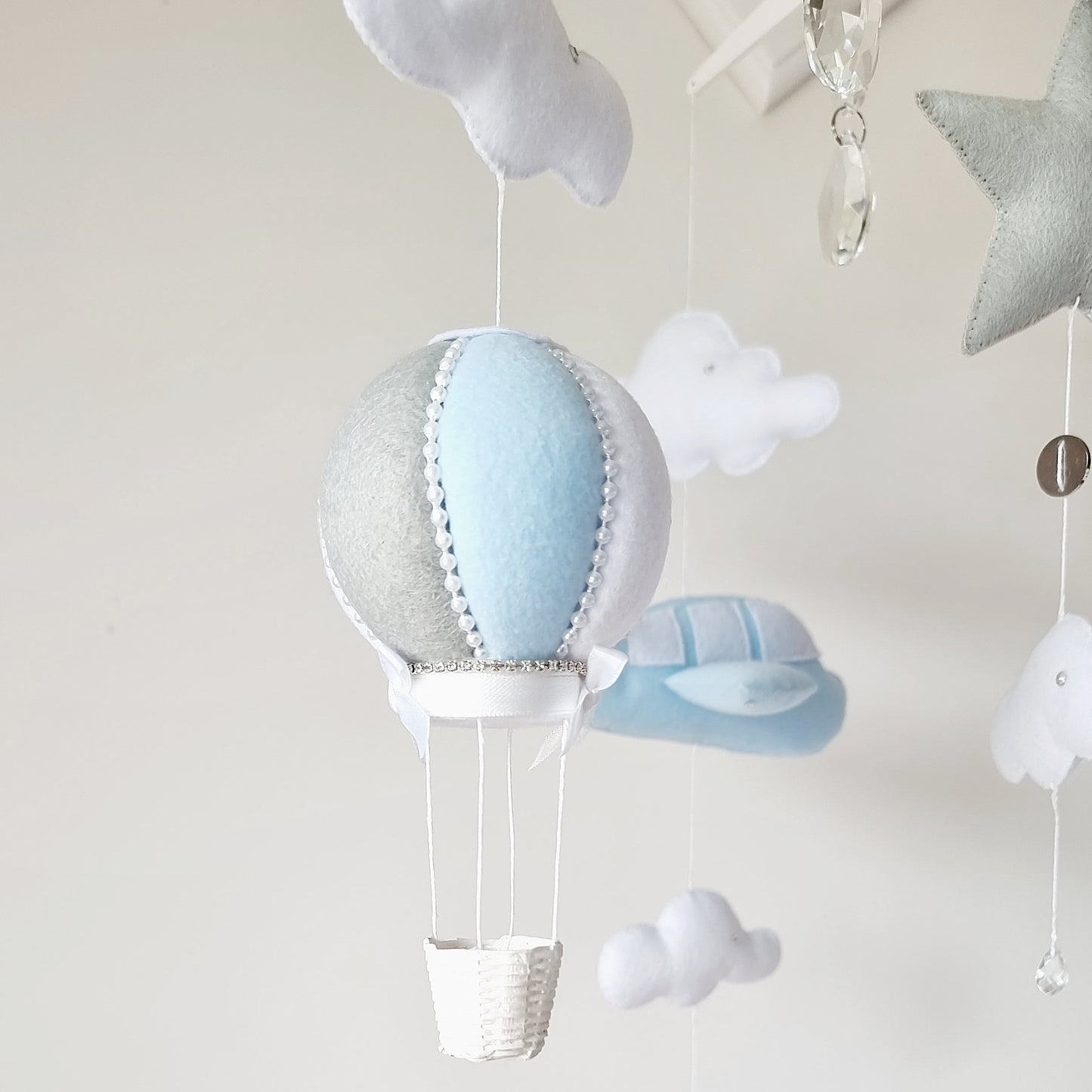 Baby nursery mobile with a hot air balloon, blue felt airplanes, white clouds, and sparkling crystal accents.